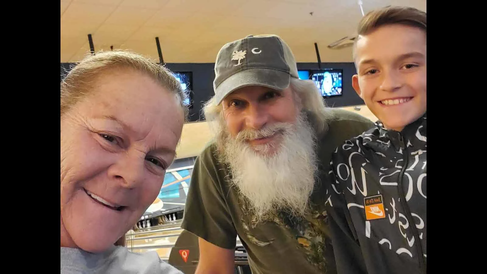 Cary Garmann, center, smiles for a photo during a bowling outing with his wife and grandson.