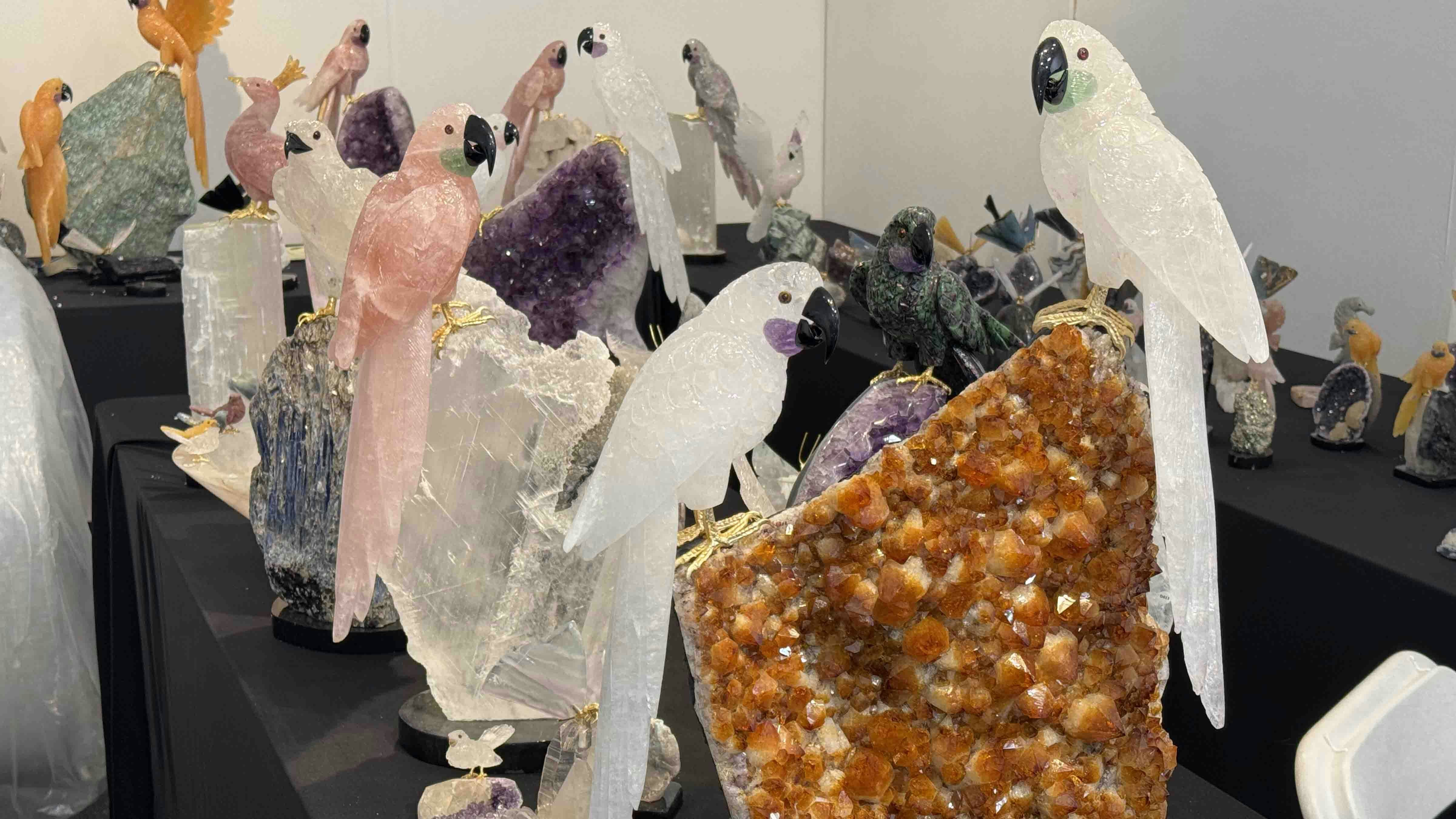 Mineral specimens and carved crystal birds on display at the 22nd Street Mineral, Fossil, and Gem Show during the 2025 Tucson Gem and Mineral Show.