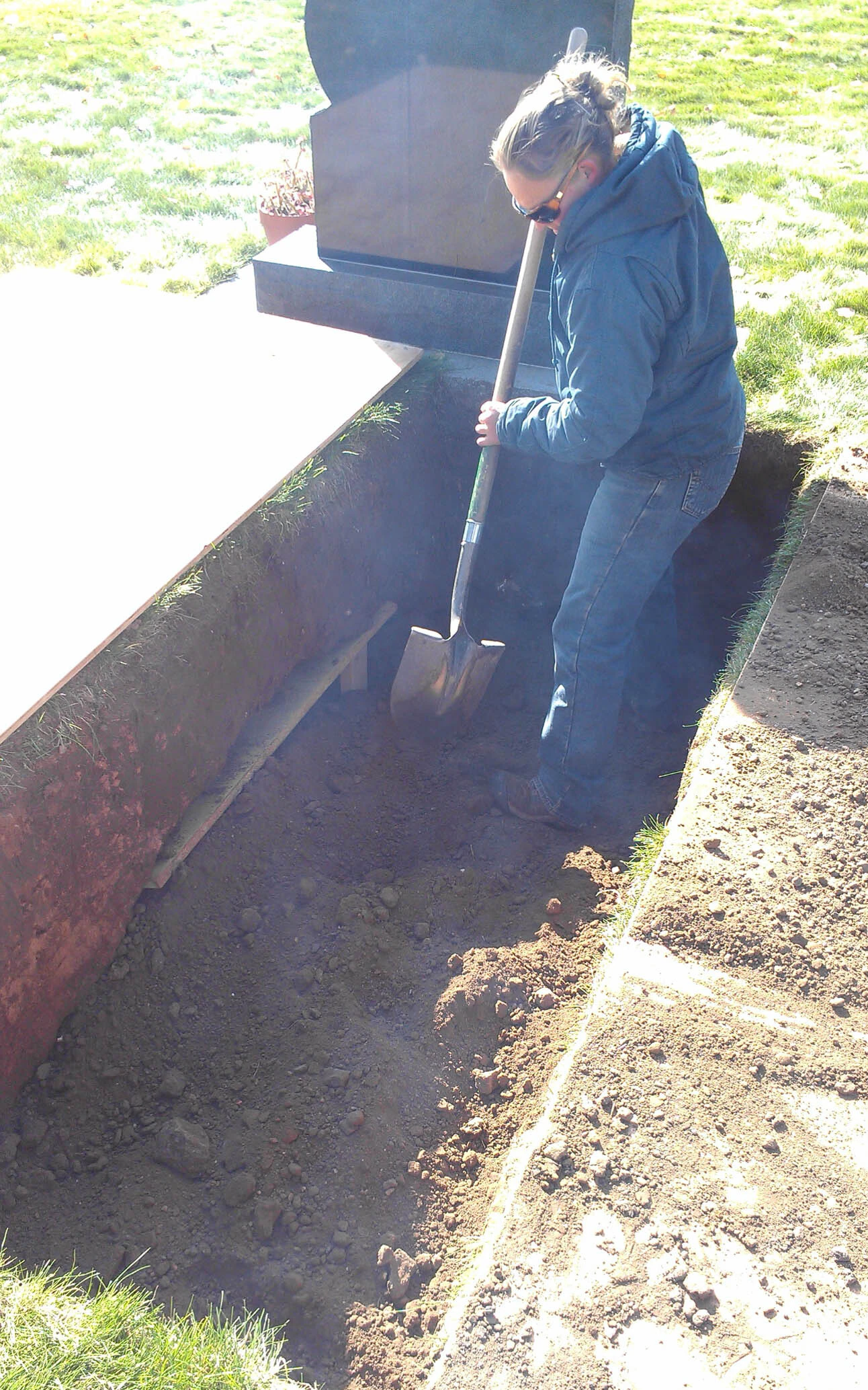Wilson works inside a grave at Greenhill Cemetery in Laramie. While machinery does most of the digging, tight corners, rocks and precise grave dimensions can still require shovel work by hand.