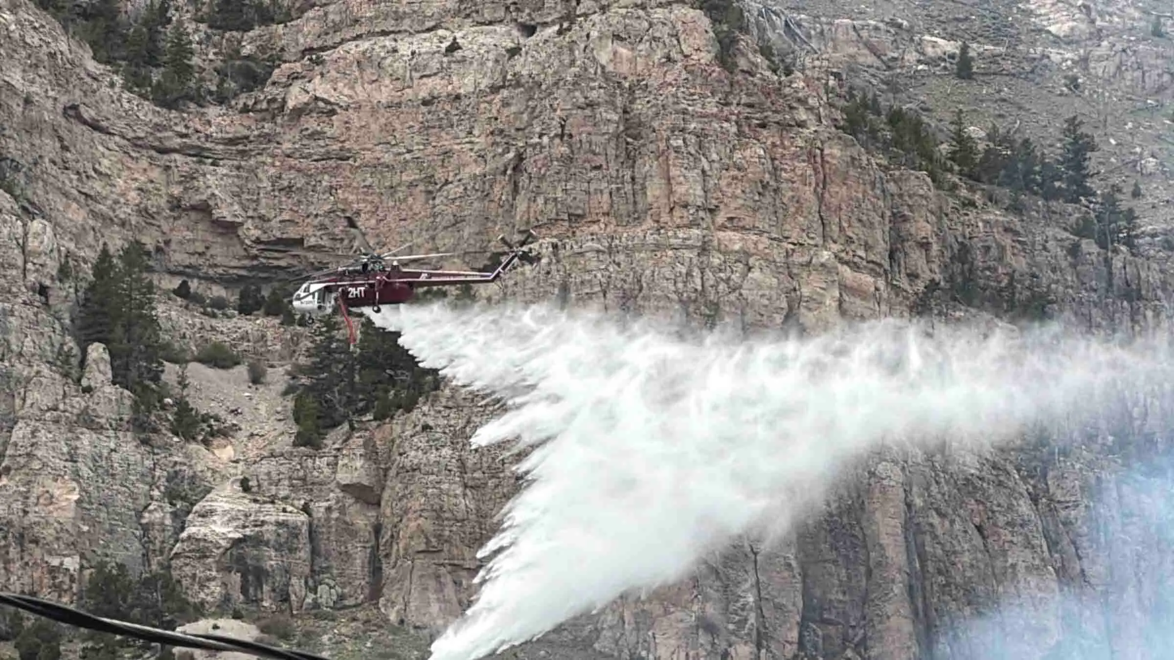 The first helicopter arrives to drop water on the Wind River Canyon fire on Saturday, May 16, 2026