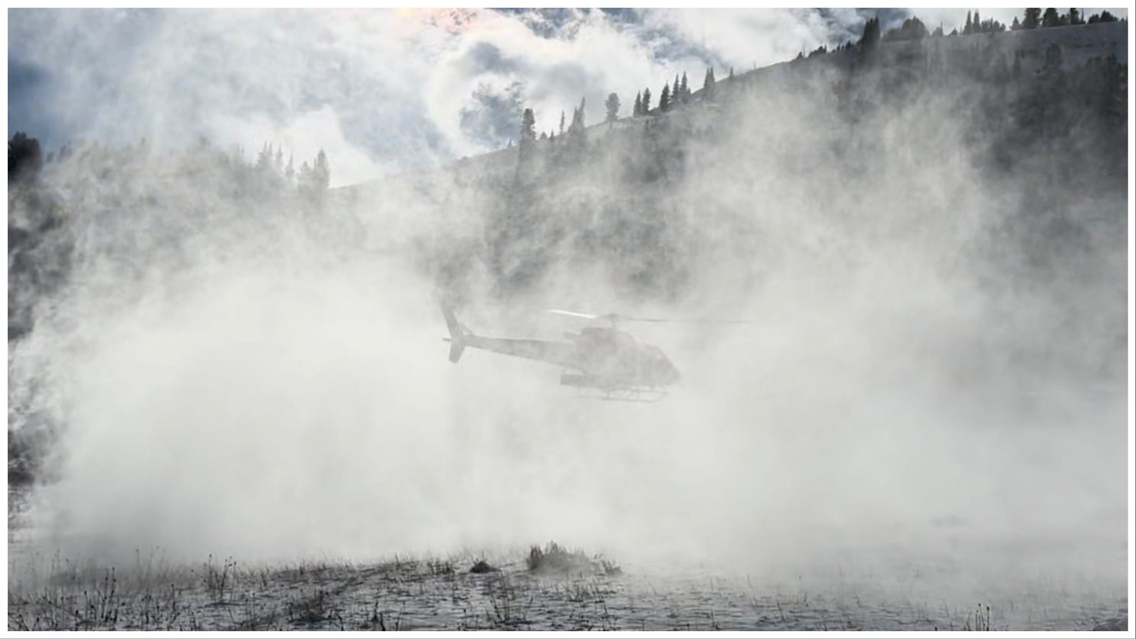 A search and rescue helicopter that helped search for Dan Mulholland kicks up loose snow.