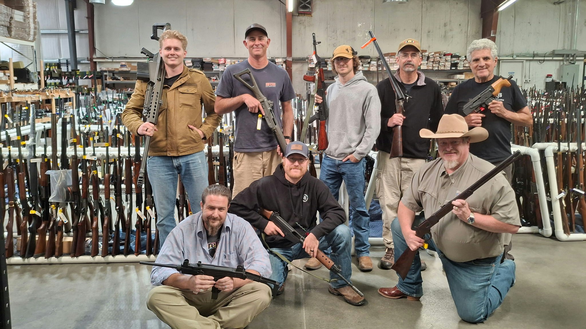 Men holding firearms at an auction house.