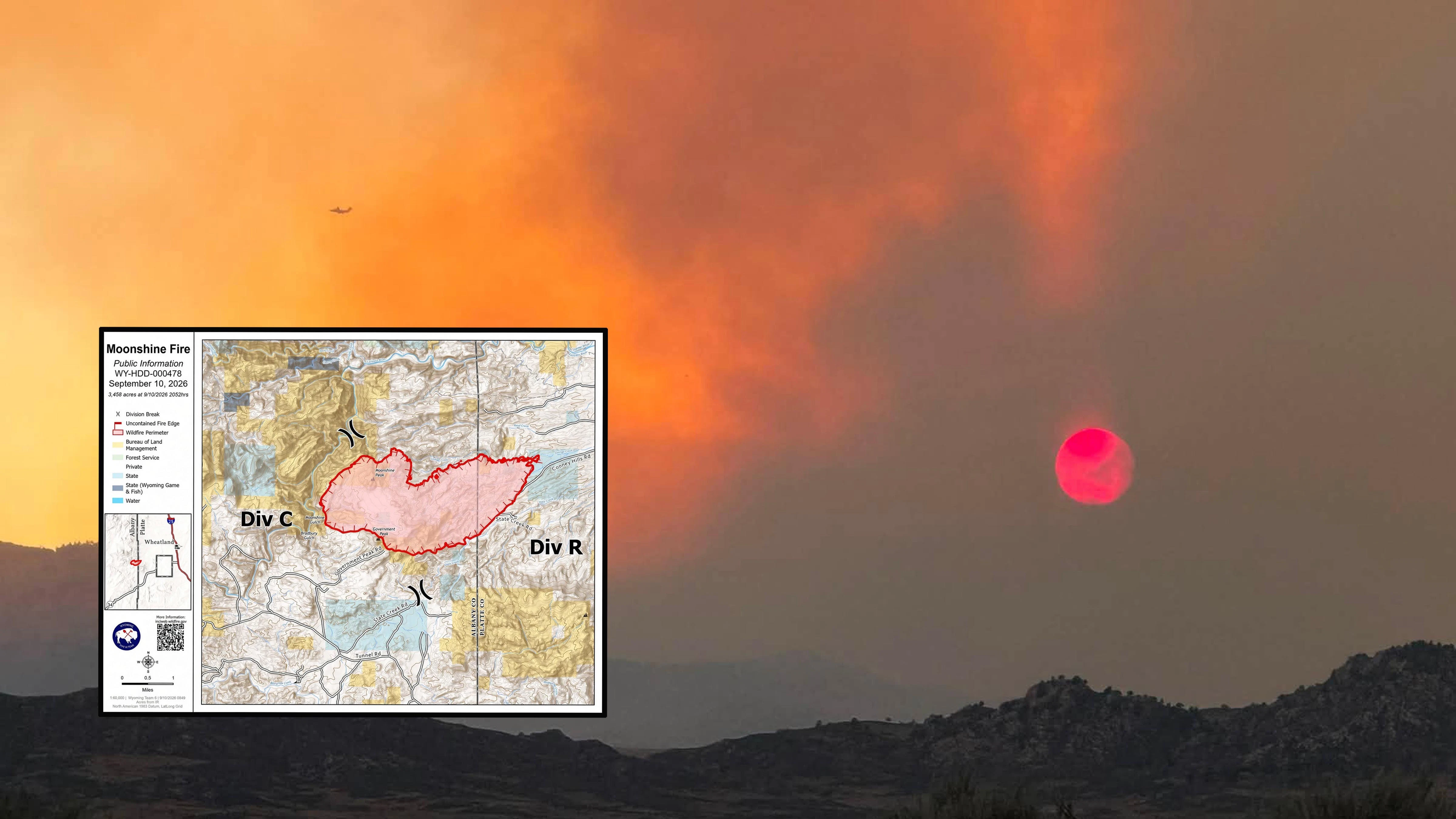 The sun glows red through thick smoke from the Moonshine Fire on Wednesday afternoon as aircraft work above the blaze in the Laramie Range.