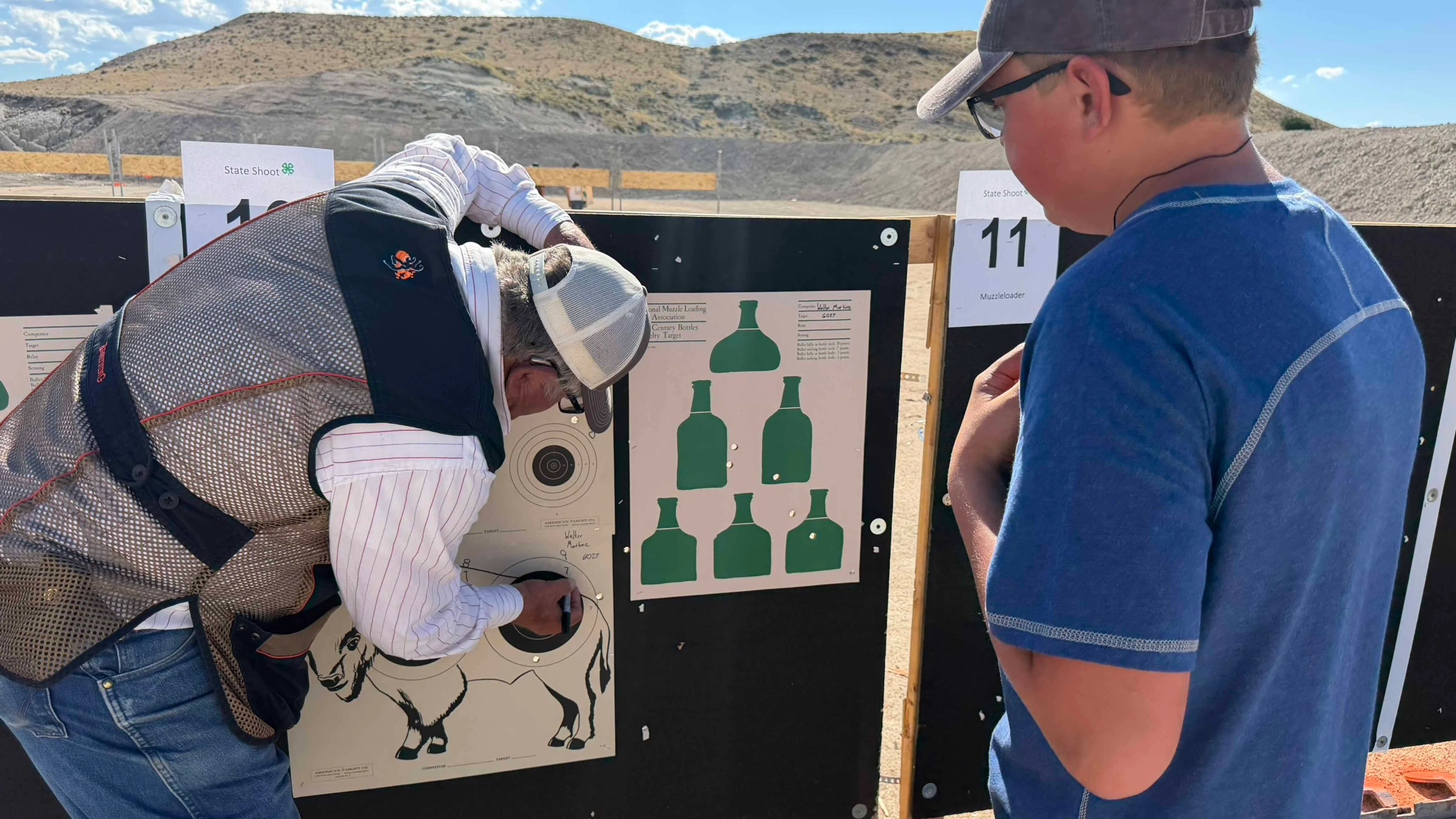 Range Official Mike Moon checks the target for 4H shooter, Walter Martinz. Eighty-five 4H kids competed in Douglas at the Wyoming State Shoot this past weekend.