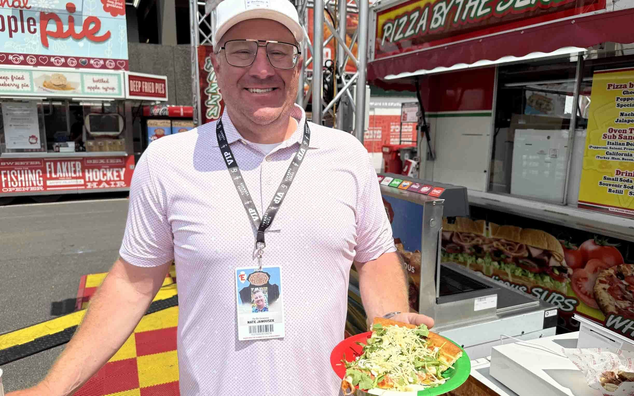 Nate Janousek, whose company Fun Biz is the exclusive concessionaire for Cheyenne Frontier Days, shows off his pistachio goat cheese pizza drizzled with hot honey.