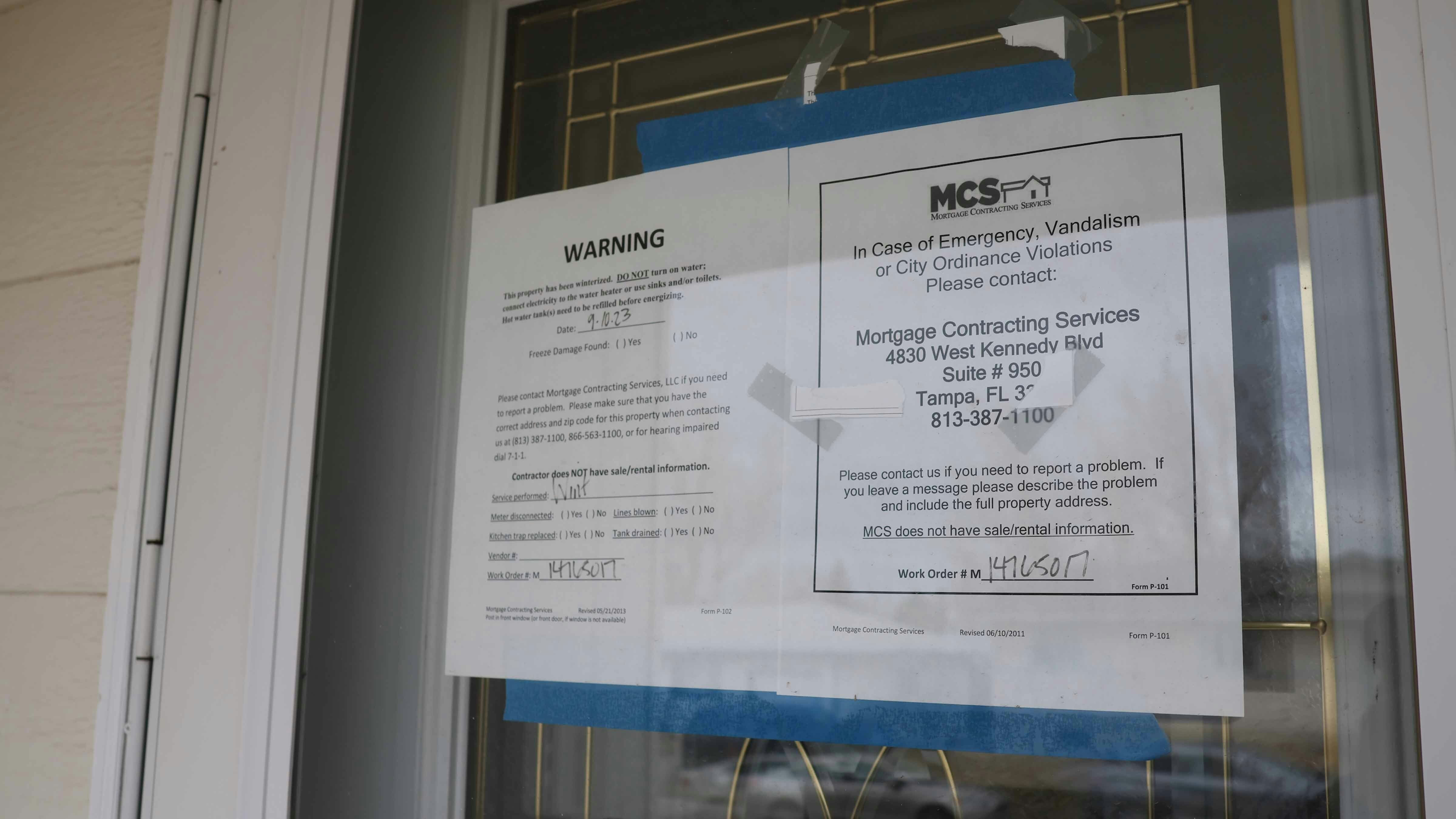 A sign on the door of the house at 2141 Thorndike Ave. directs people to a Florida mortgage company for issues.
