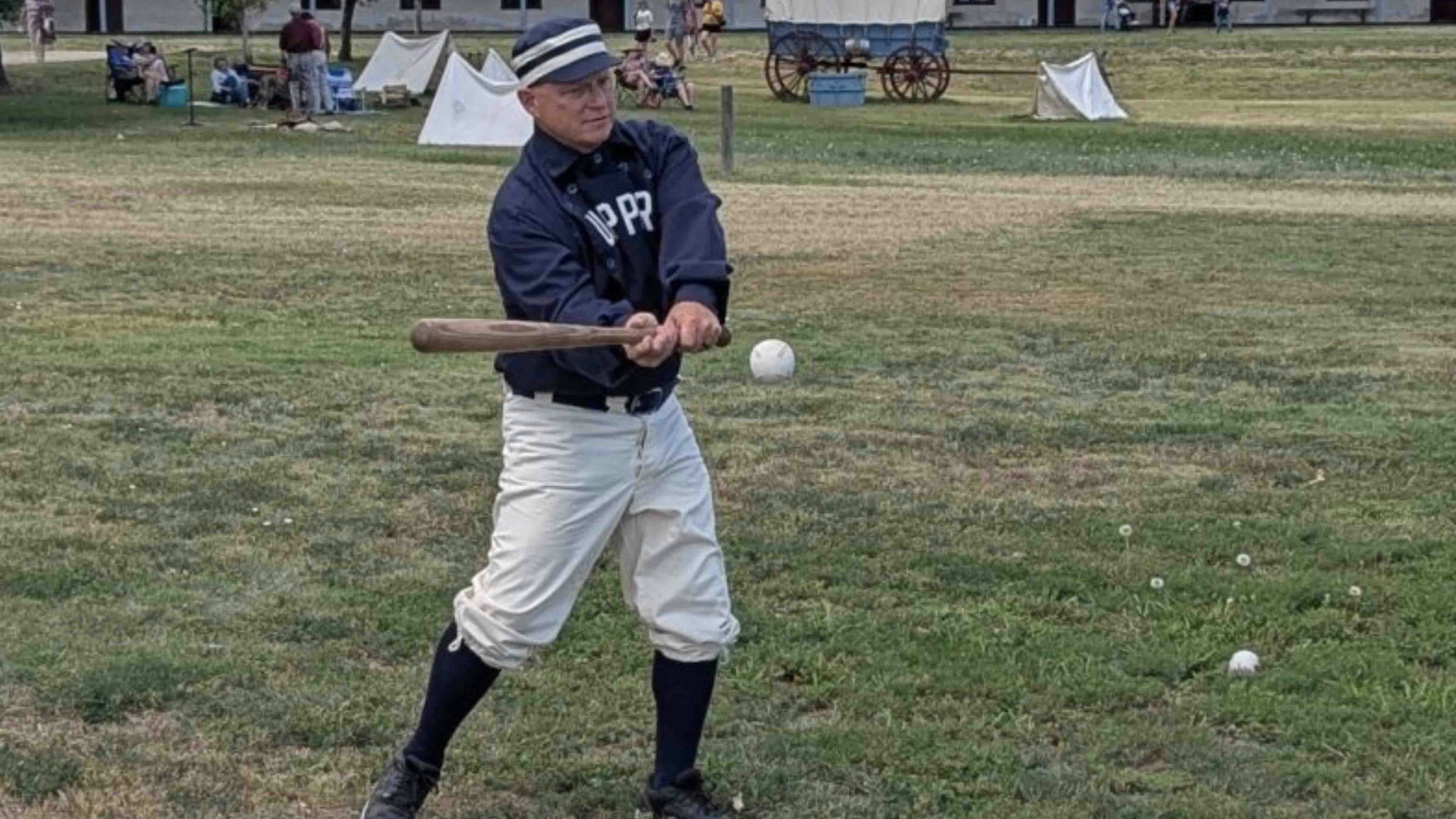 A batter strikes a ball during a demonstration of the National Pastime under the rules of the 1860s during the Fort Laramie National Historic Site Independence Day celebration.