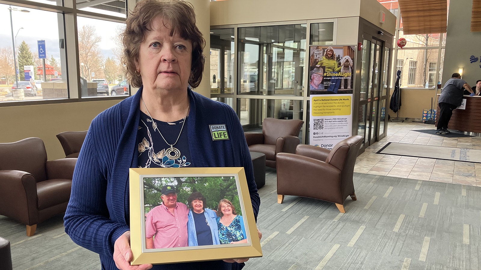 Kidney recipient Anne Bina holds a photo of the parents of the boy whose donated kidney has given her life. The couple and Bina now have a close relationship.