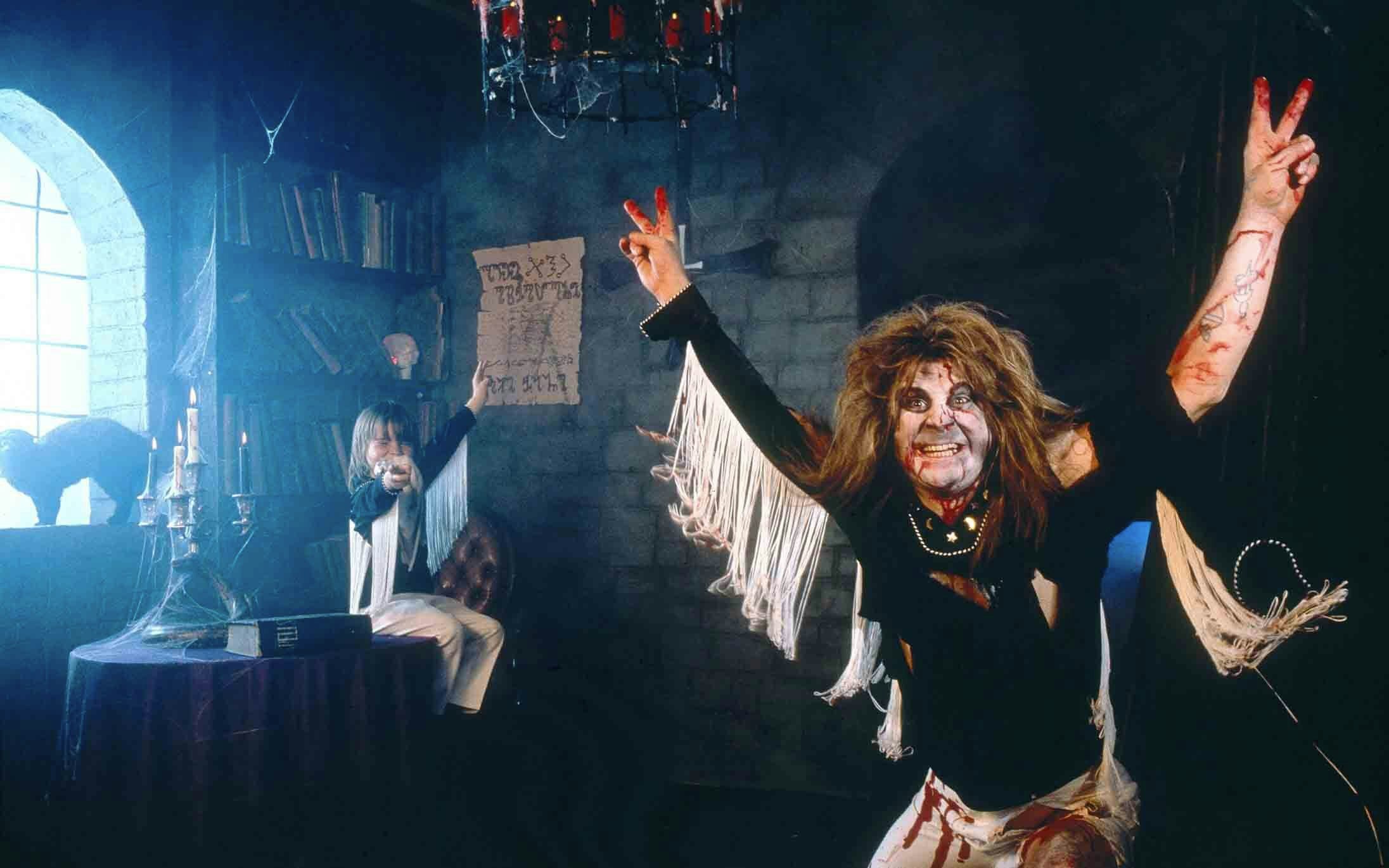 Ozzy Osbourne with his son Louis Osbourne in the background dressed as him, wearing ripped clothes and zombie make up, during 'Diary of a Madman' album cover session