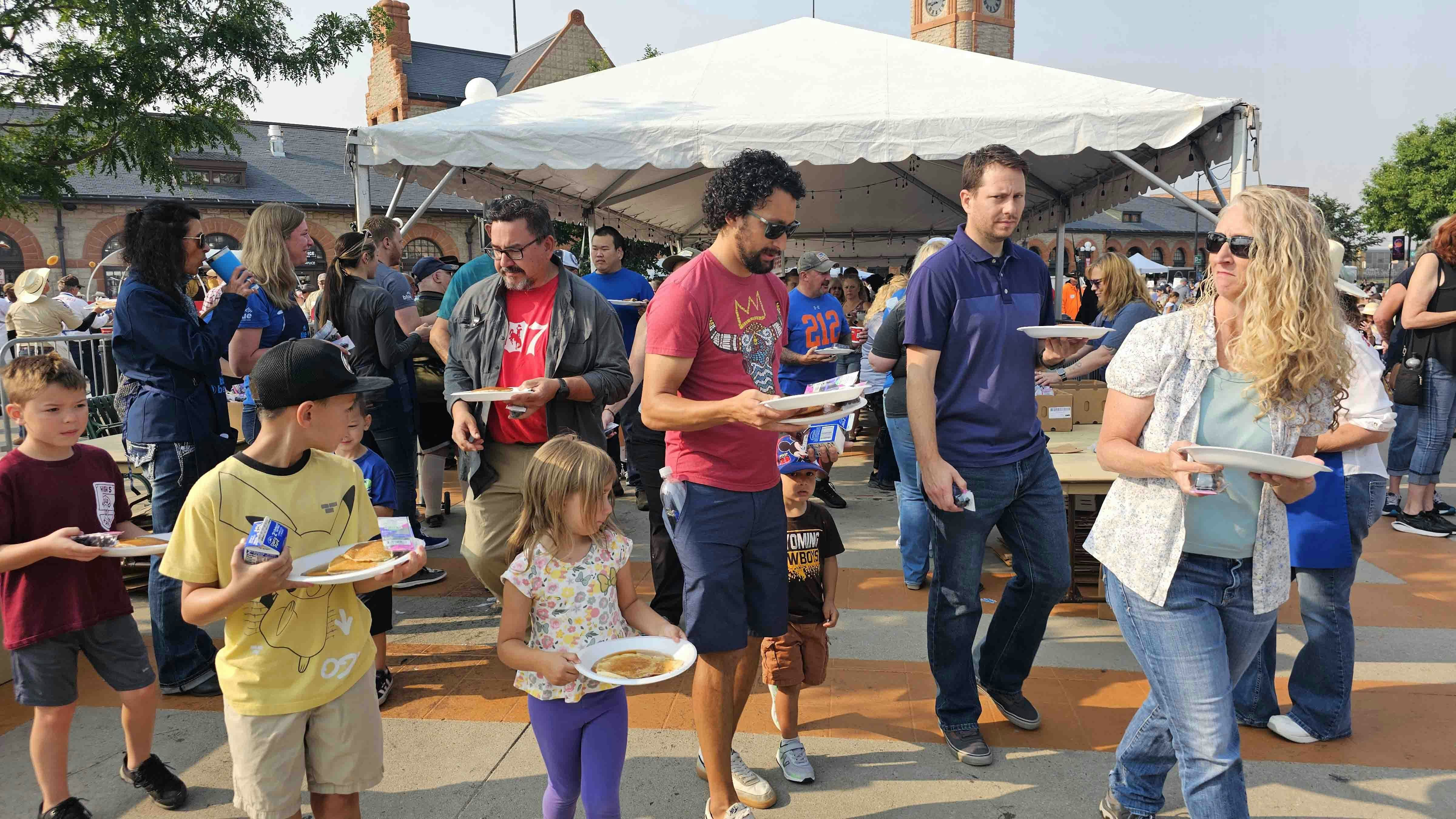 People with pancakes stream from the line, which moves rapidly.