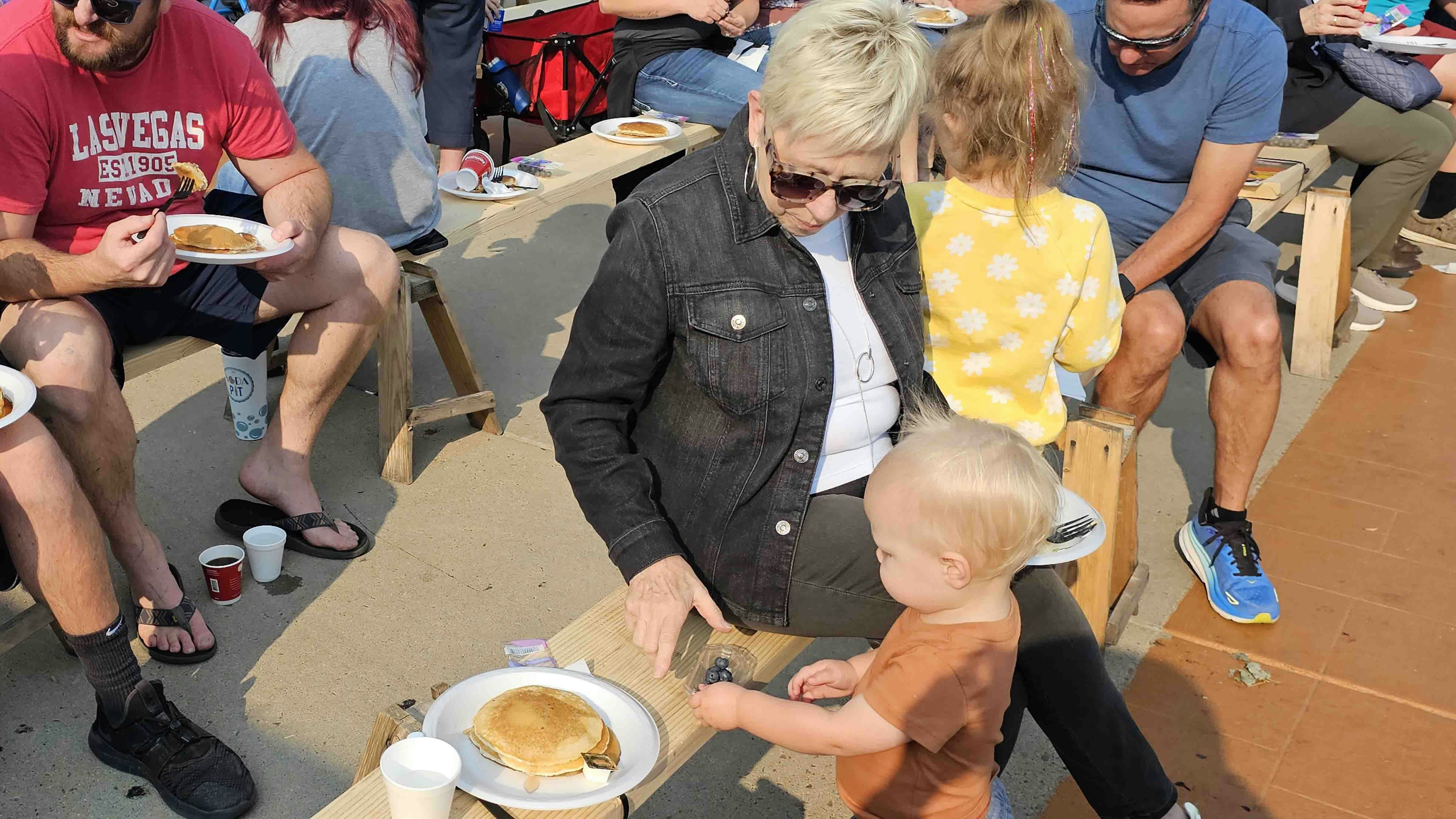 Pam Marshall watches over Christian Nolan who seems to be enjoying the blueberries more than the pancakes.