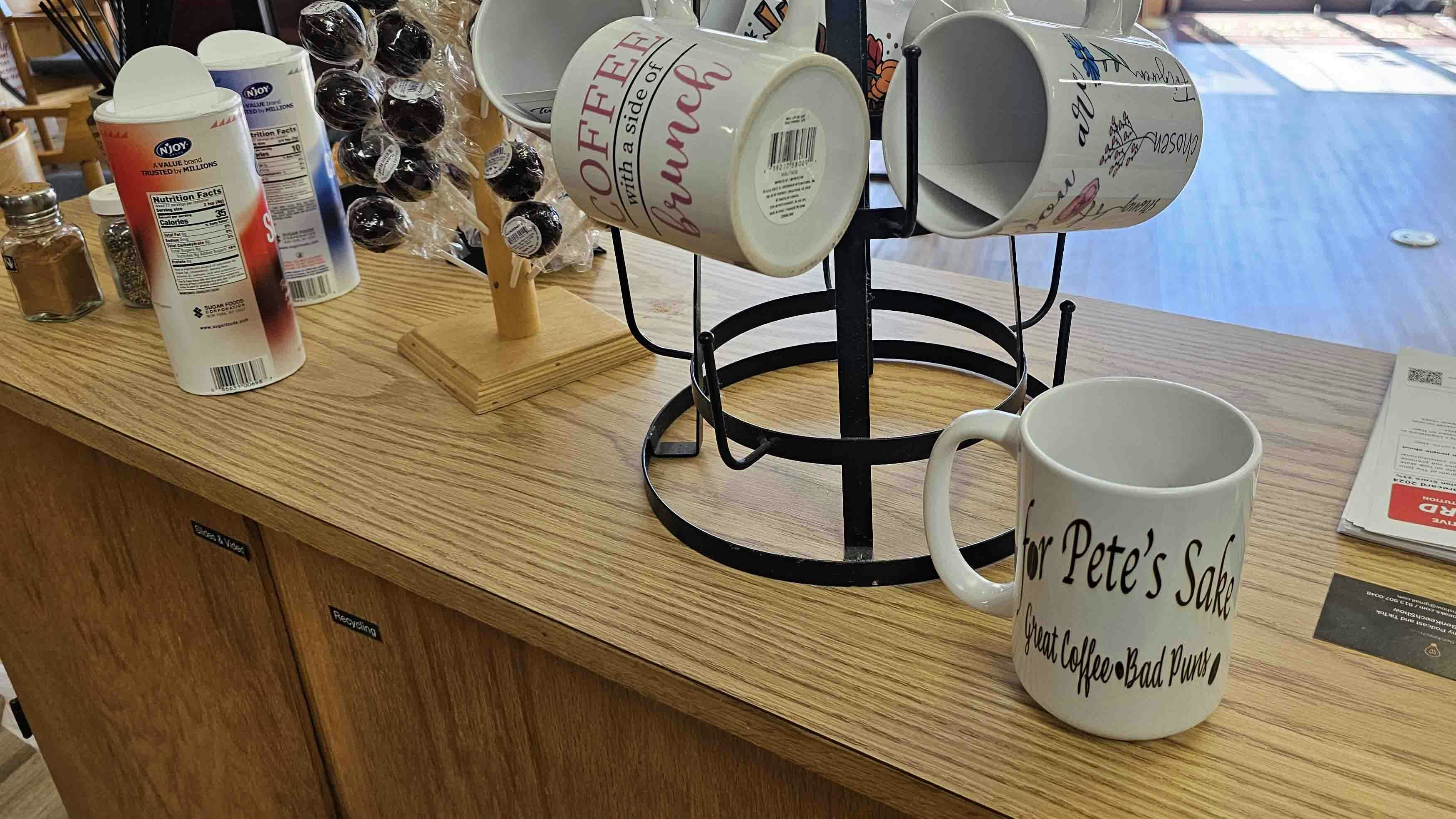 Mugs with "For Pete's Sake ... Great Coffee • Bad Puns" on them are for sale at the Evanston coffee shop.