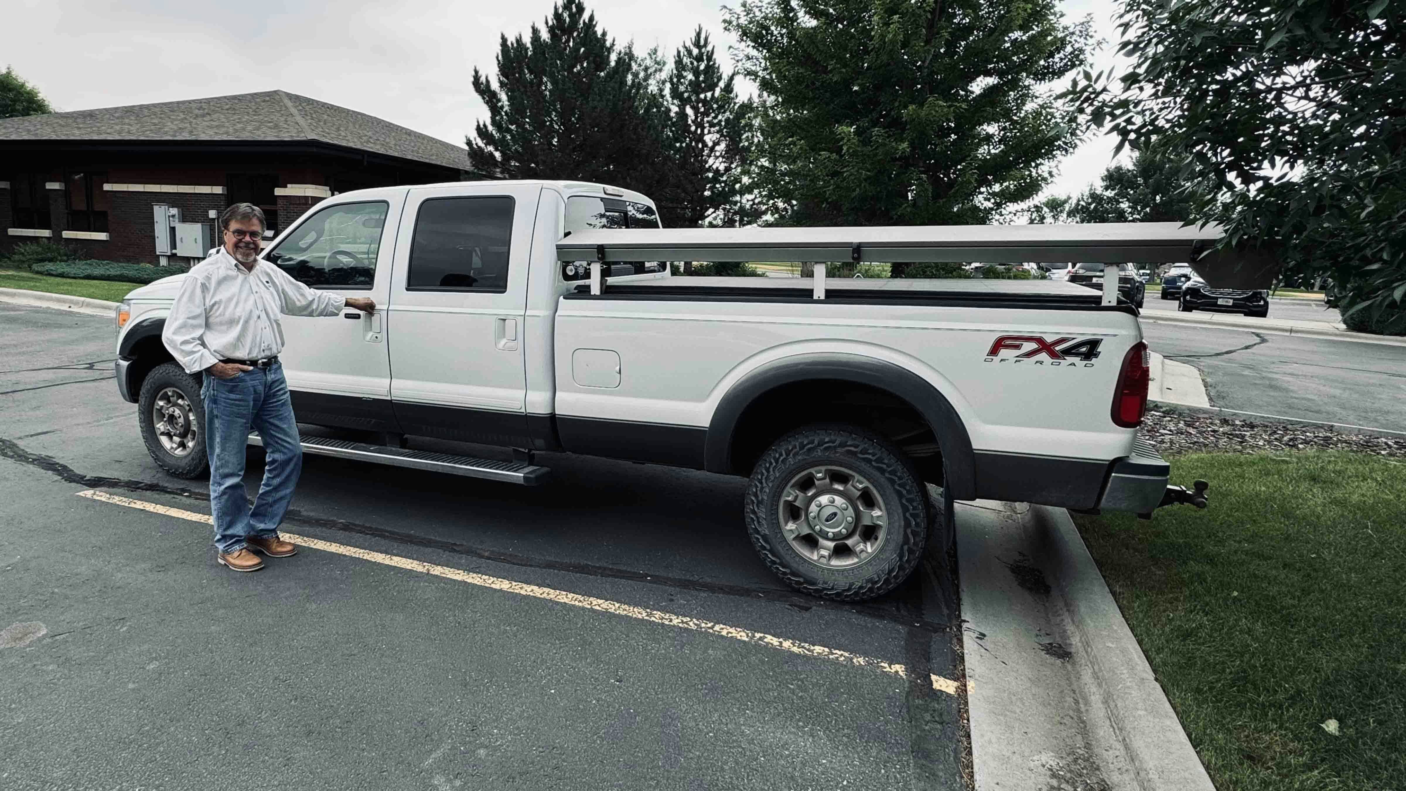 Wyo-Ben Inc. CEO David Brown stands in front of the Ford F-350 truck that he used to load a half-pallet of cat litter in the bed of his vehicle to haul home to his cats.