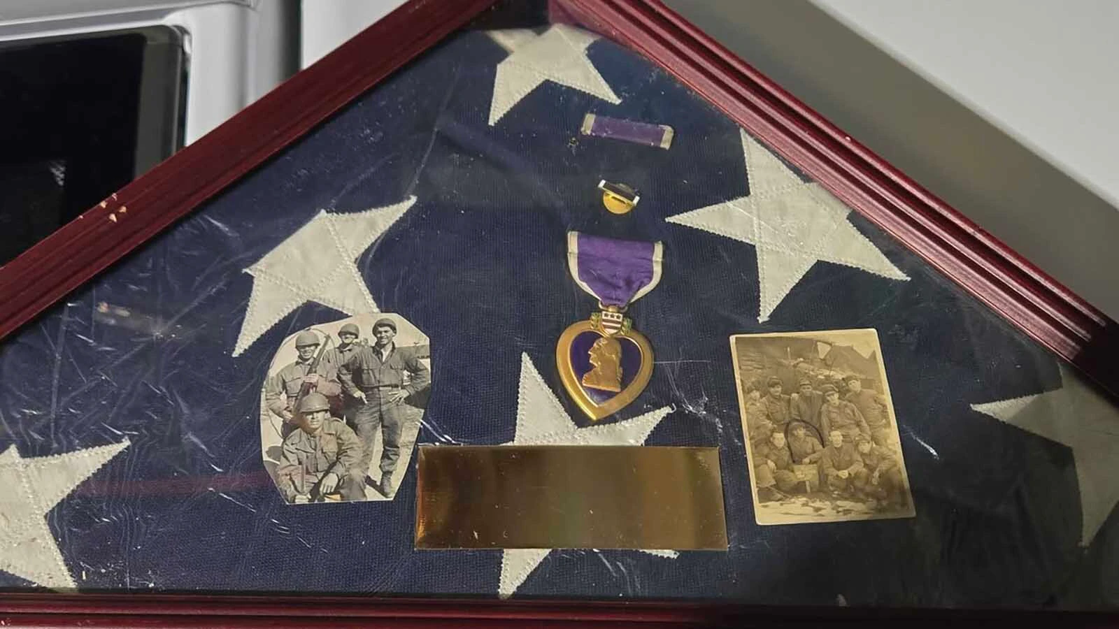 A photo of the American flag, Purple Heart, and photos a Gillette man and his sister recently understood they had gathered up a few years ago. They are trying to find the true heirs to the property.