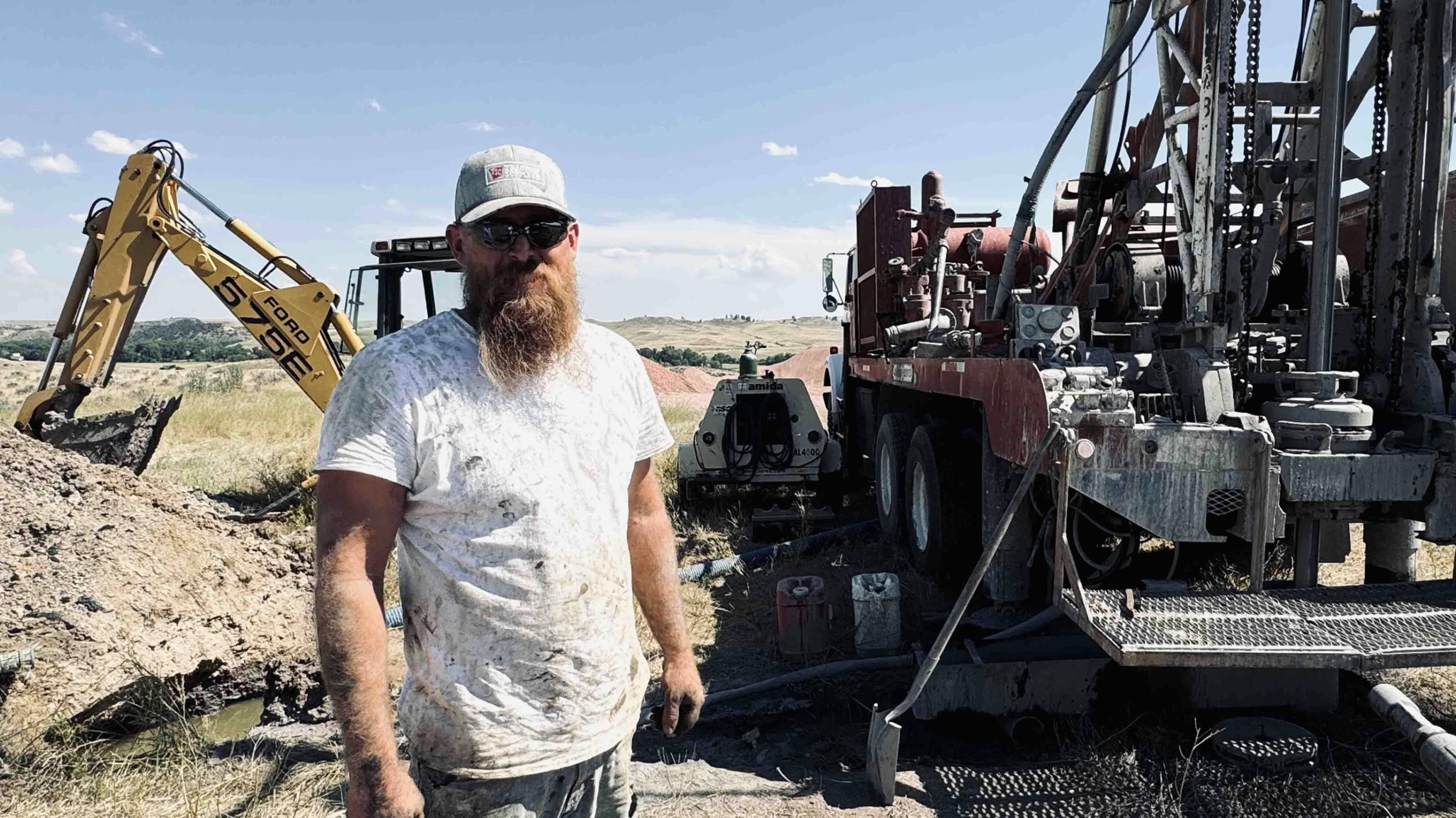 Drilling rig worker Zachary Christensen stands next to the rig where he was collecting core samples from a mining operation for rare earths planned by Ramaco Resources Inc. in Ranchester, Wyoming.