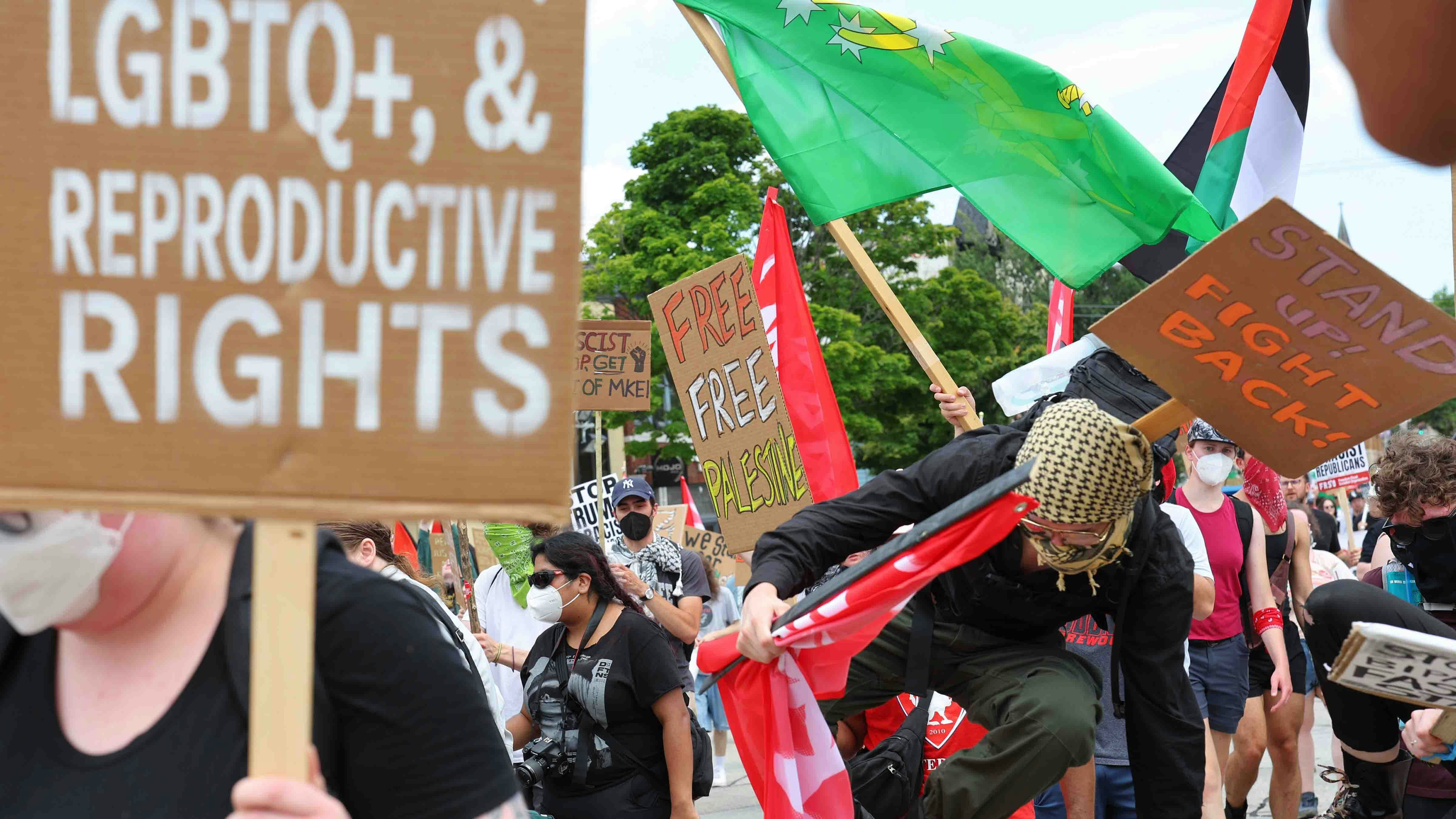 People hop over barriers as they participate in the Coalition to March on the RNC on July 15, 2024 in Milwaukee, Wisconsin.