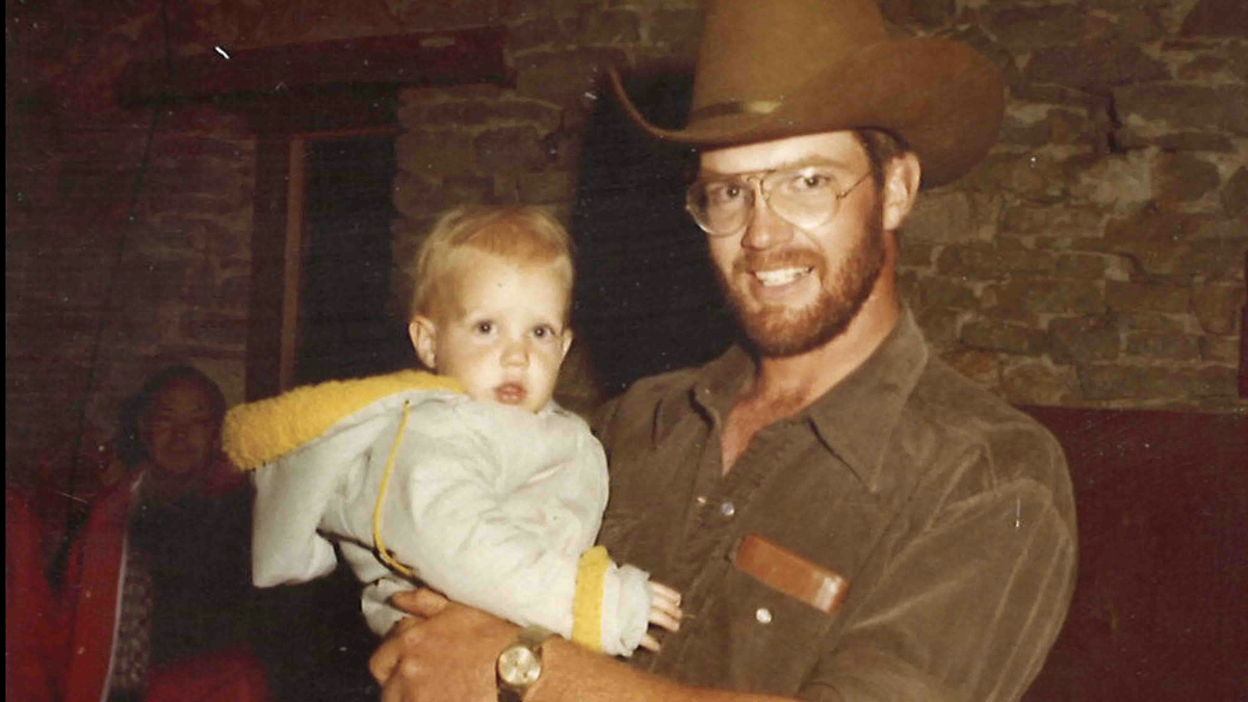 Rod Miller holding his son Ike at a barn dance on his family ranch in 1978.