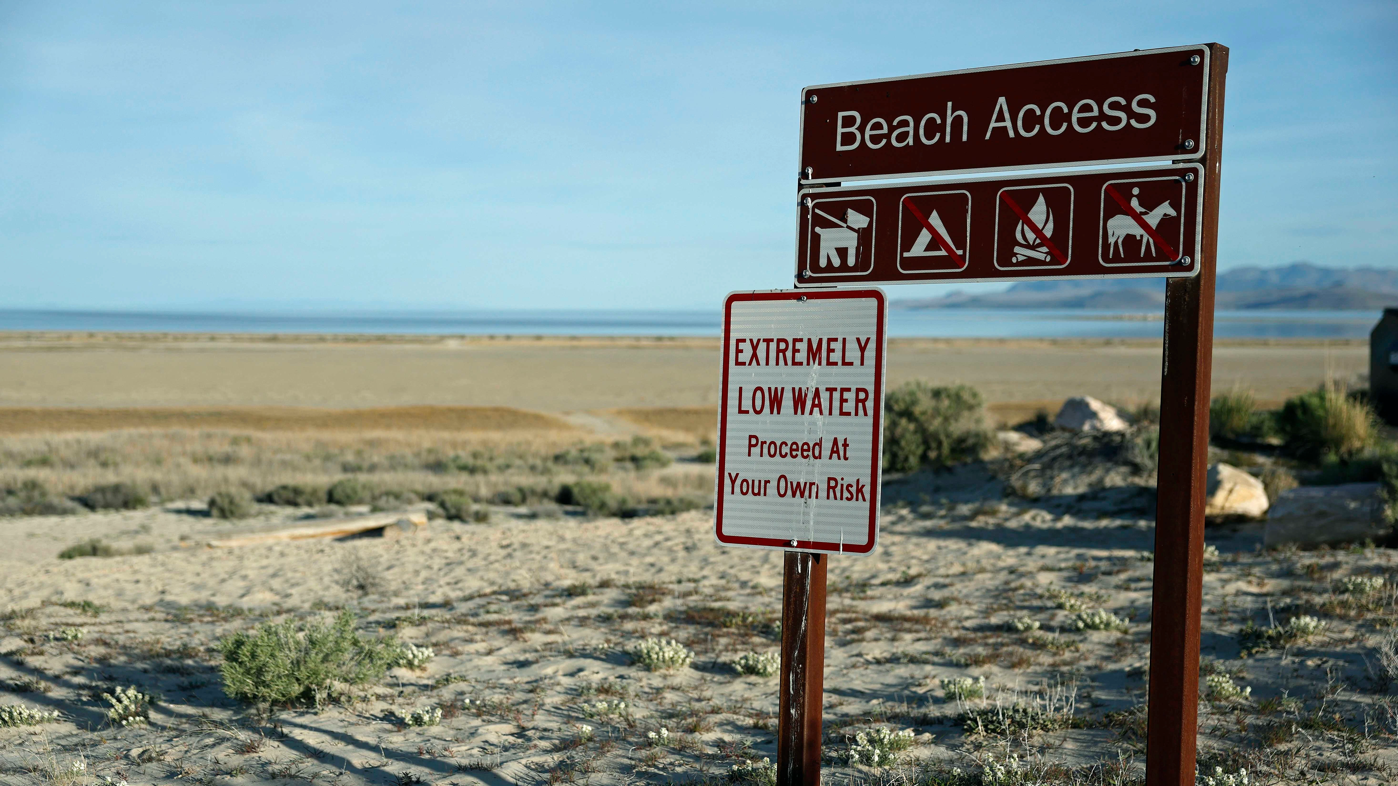 A sign warns visitors of low water levels at the Great Salt Lake's Antelope Island Marina on April 08, 2026 near Syracuse, Utah.