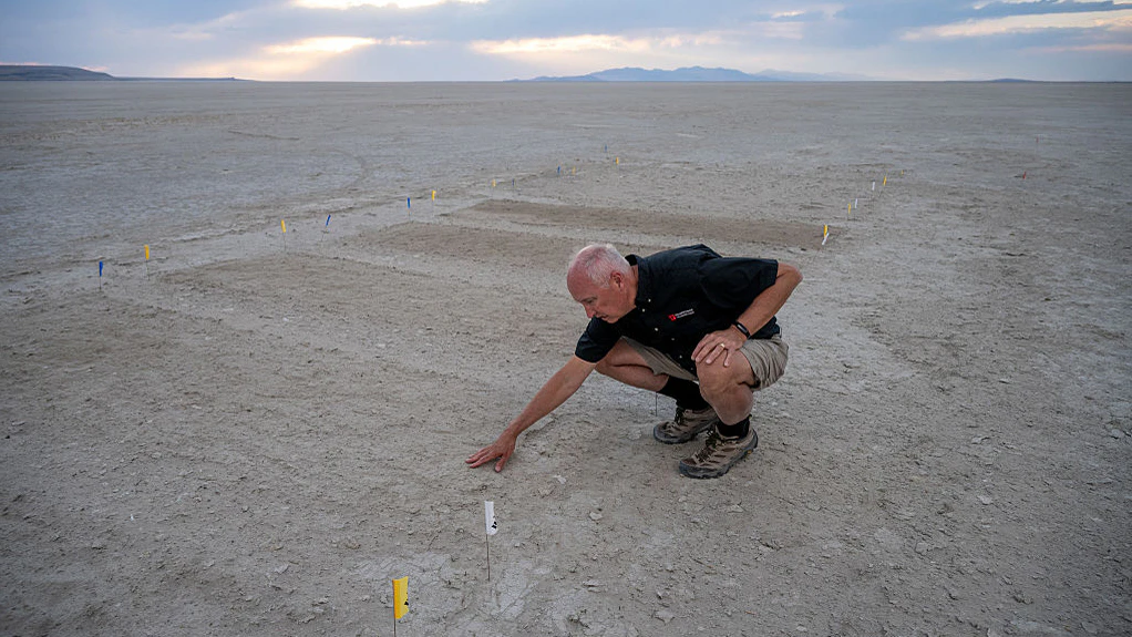 Kevin Perry, Professor of Atmospheric Sciences at the University of Utah, examines a dust mitigation test site on the exposed lakebed of Farmington Bay in Utah's Great Salt Lake on July 9, 2025. As water levels drop in Utah's Great Salt Lake, scientists are urgently working to understand the dust coming off the exposed lakebed and its potential health risks to the communities nearby.