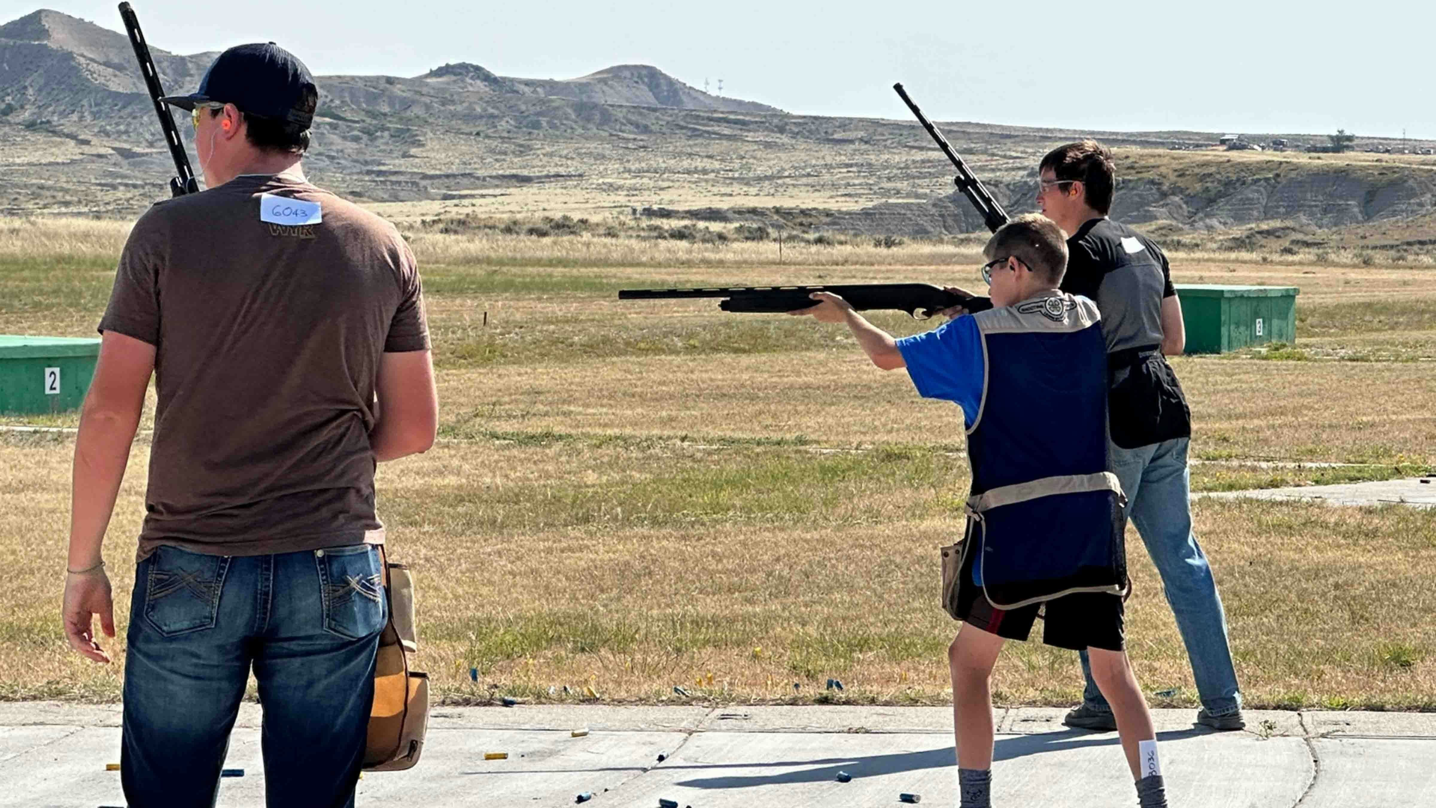 Mac McCumber takes aim during the shotgun competition while his squad leader, Hayden Overfield (far left) and teammate, Logan Dafoe (far right) wait their turn in line.