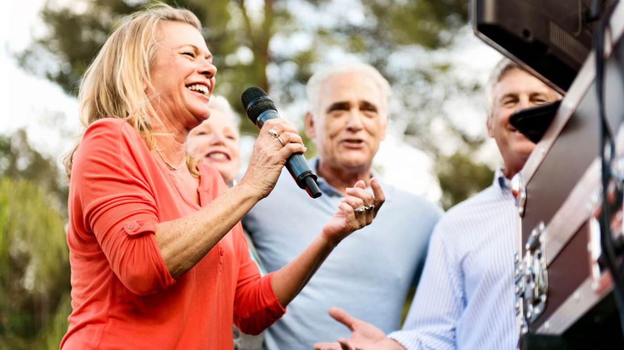 Photo of seniors singing karaoke.