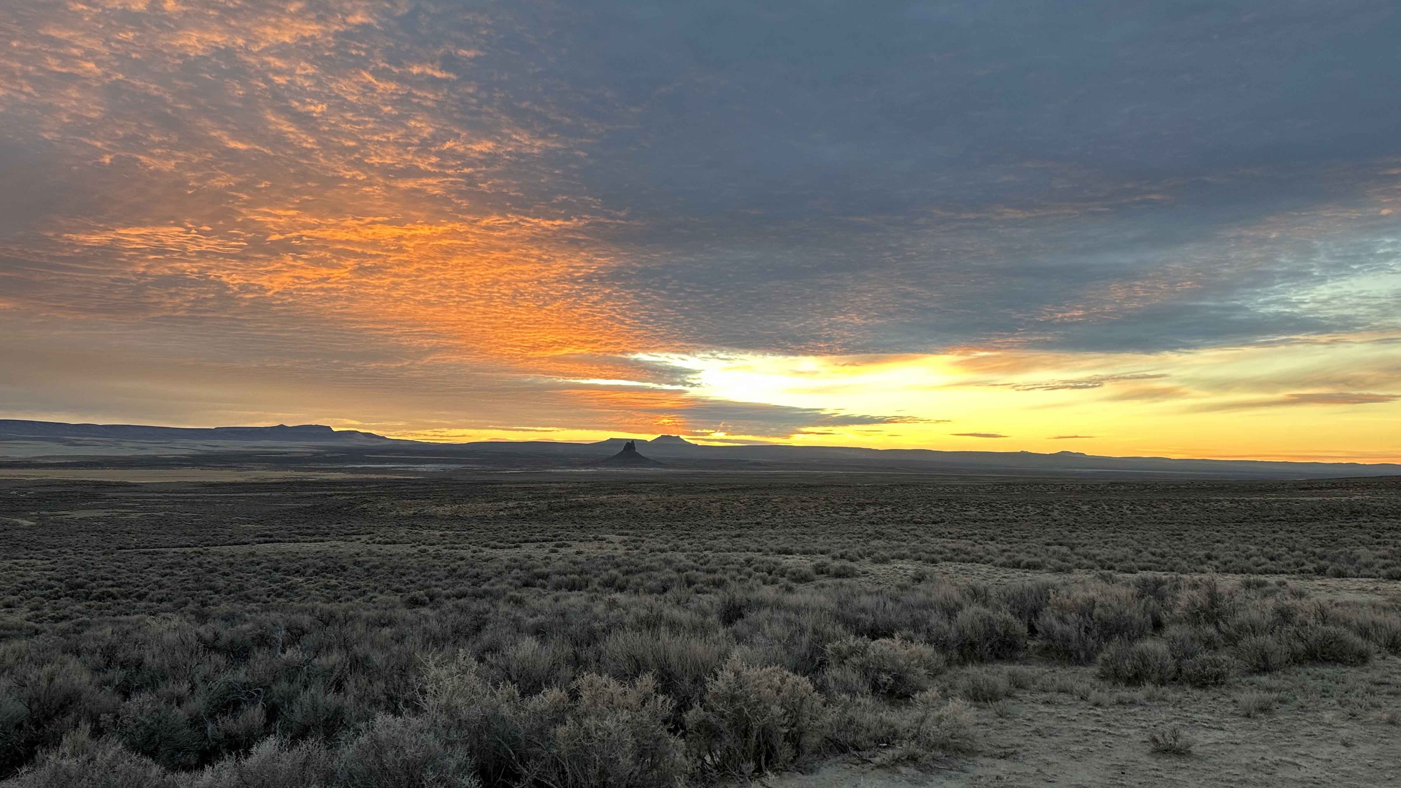 Red Desert. Steamboat Mountain on the left, Boar's Tusk and North and South Table Mountains are silhouetted on the valley floor in the center.