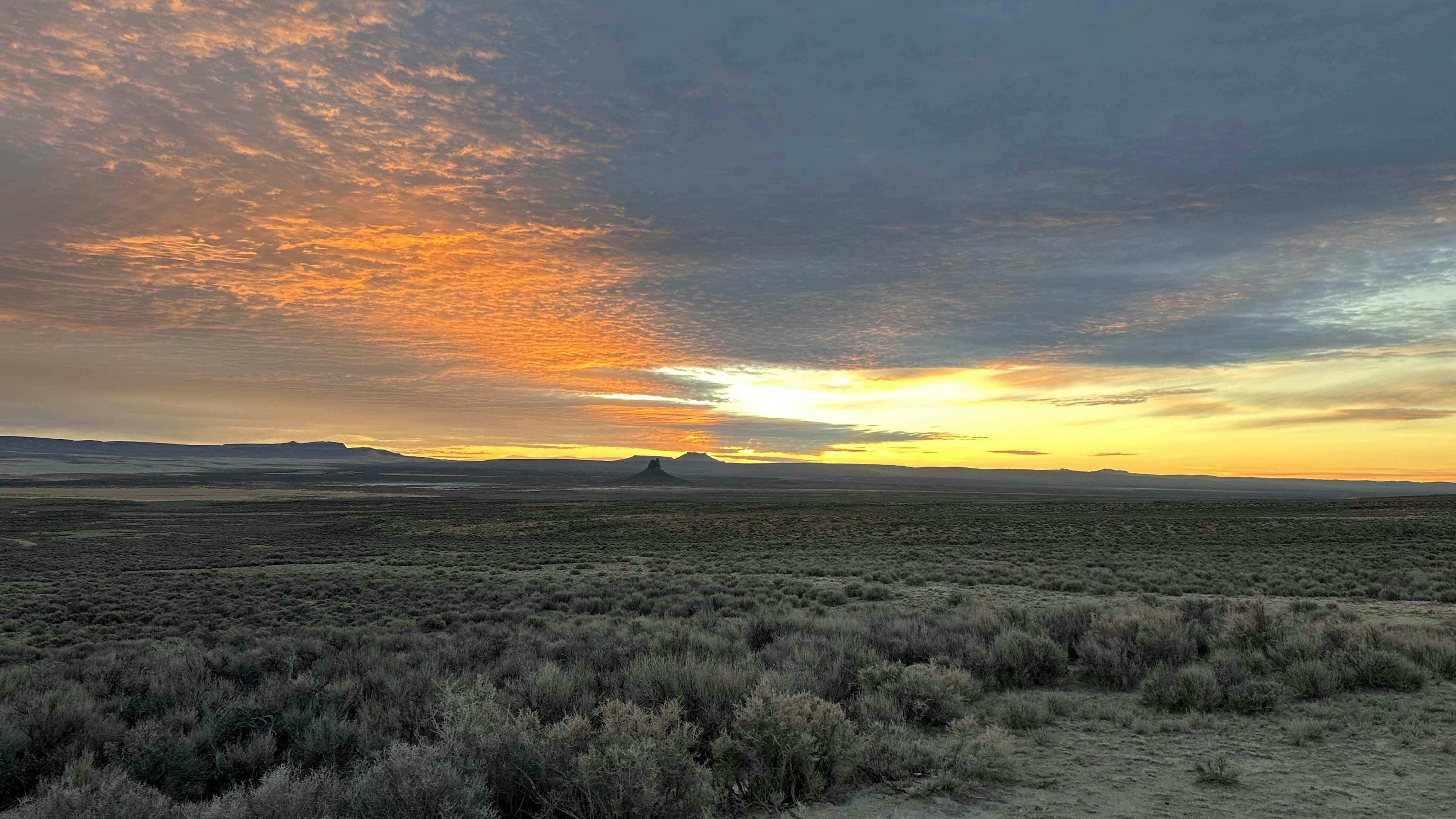 Red Desert. Steamboat Mountain on the left, Boar's Tusk and North and South Table Mountains are silhouetted on the valley floor in the center.