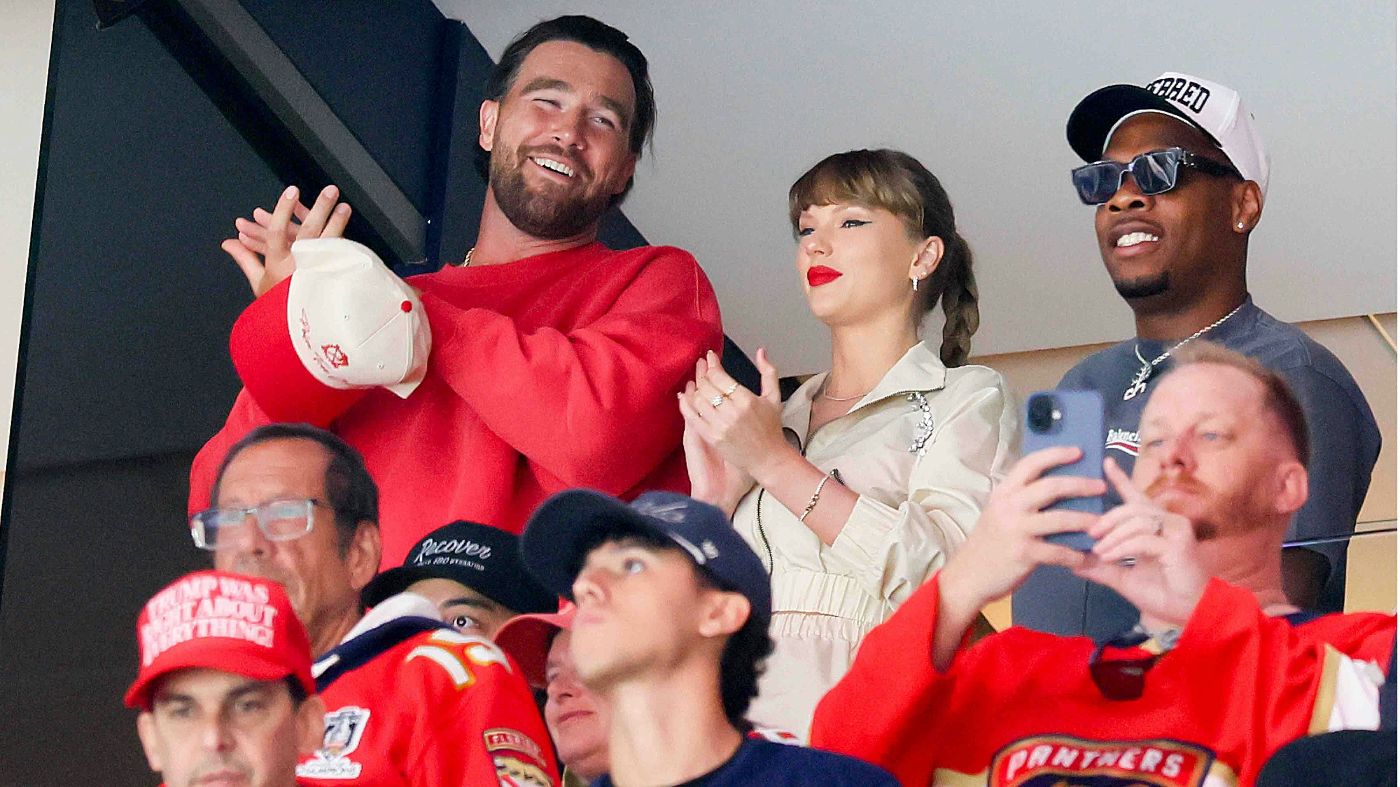 Travis Kelce, left, Taylor Swift and Aric Jones react as the Edmonton Oilers and the Florida Panthers play during the first period in Game Four of the 2025 Stanley Cup Final at Amerant Bank Arena on June 12, 2025