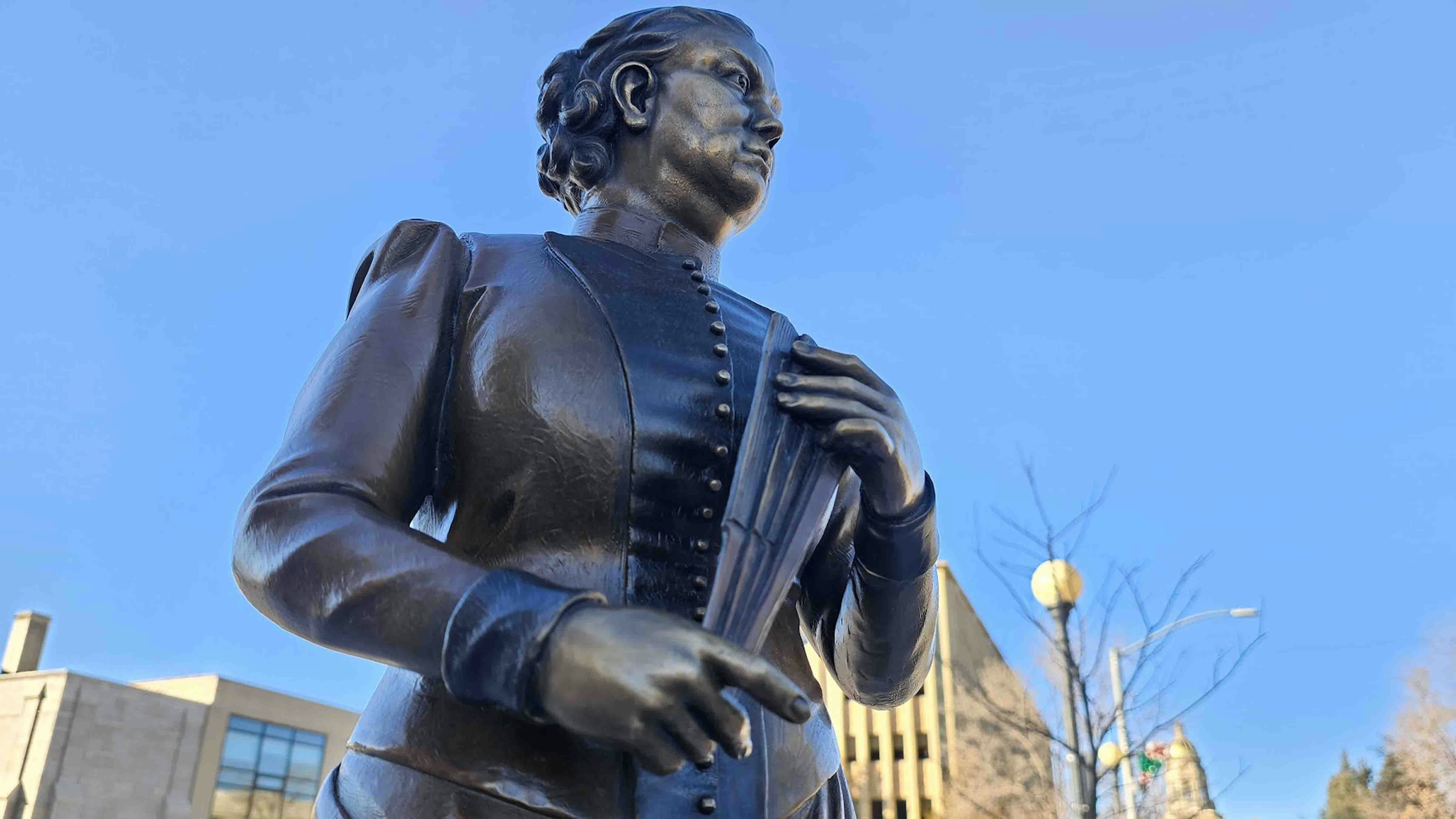 Therese Jenkins, sculpted by Joel Turner, with the Cheyenne Capitol in the background. Jenkins was a leading advocate of both the women's suffrage and the temperance movements