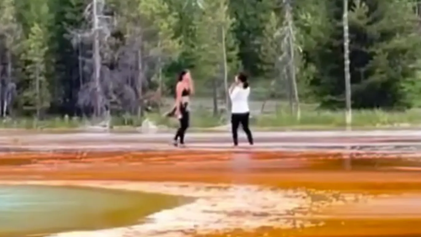 Two tourists were seen getting dangerously and illegally close to Grand Prismatic Spring on Sunday in Yellowstone National Park, enraging hundreds of spectators and millions of internet onlookers.