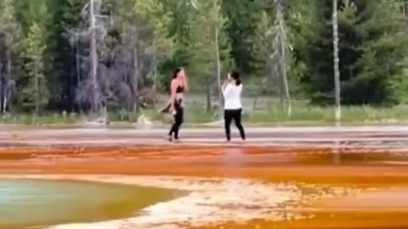 Two tourists were seen getting dangerously and illegally close to Grand Prismatic Spring on Sunday in Yellowstone National Park, enraging hundreds of spectators and millions of internet onlookers.