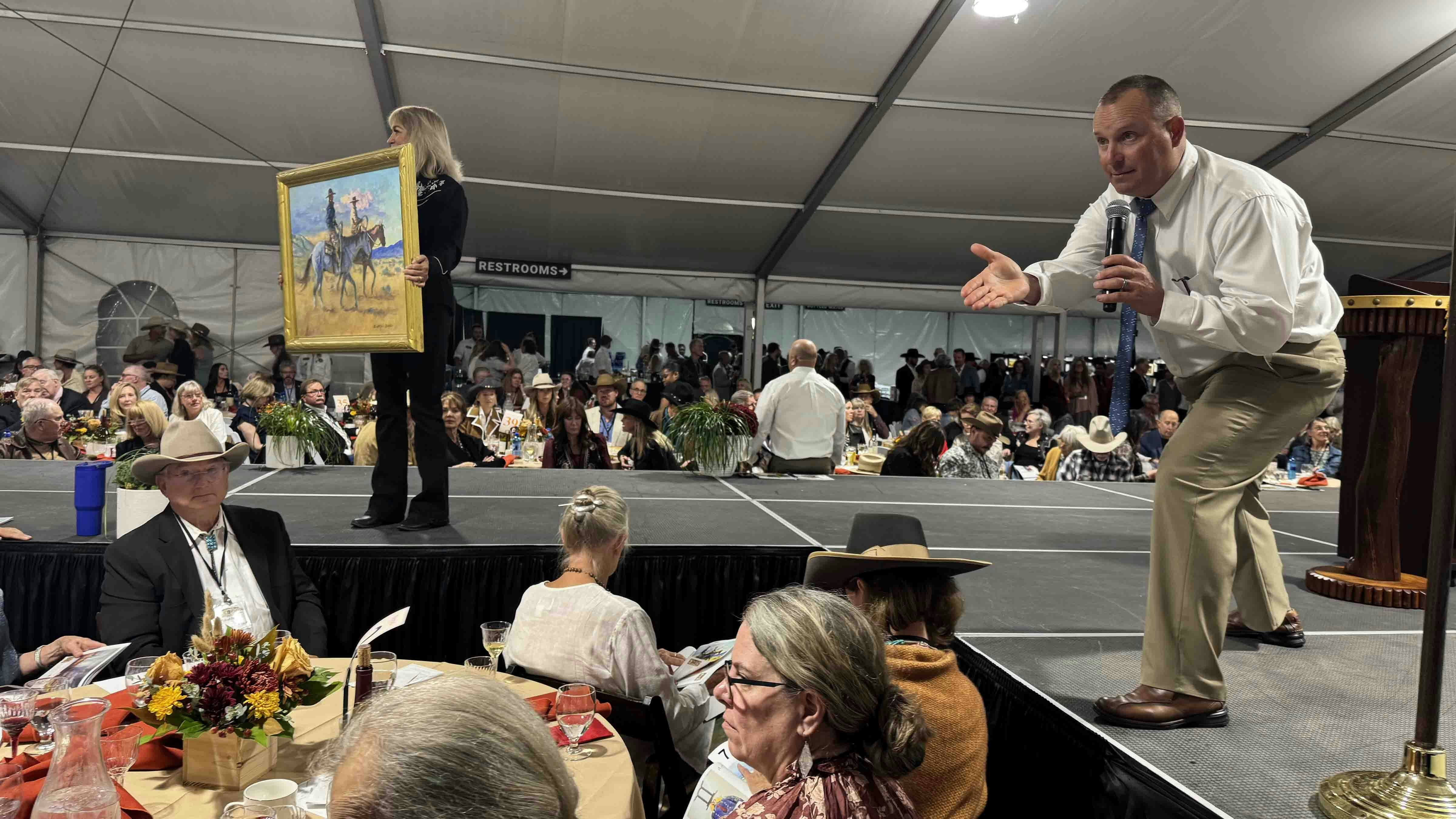 Auctioneer Troy Black keeps the momentum going for "Out Cody Way," an oil painting by Buckeye Blake, during the 44th Buffalo Bill Art Show and Sale in Cody.