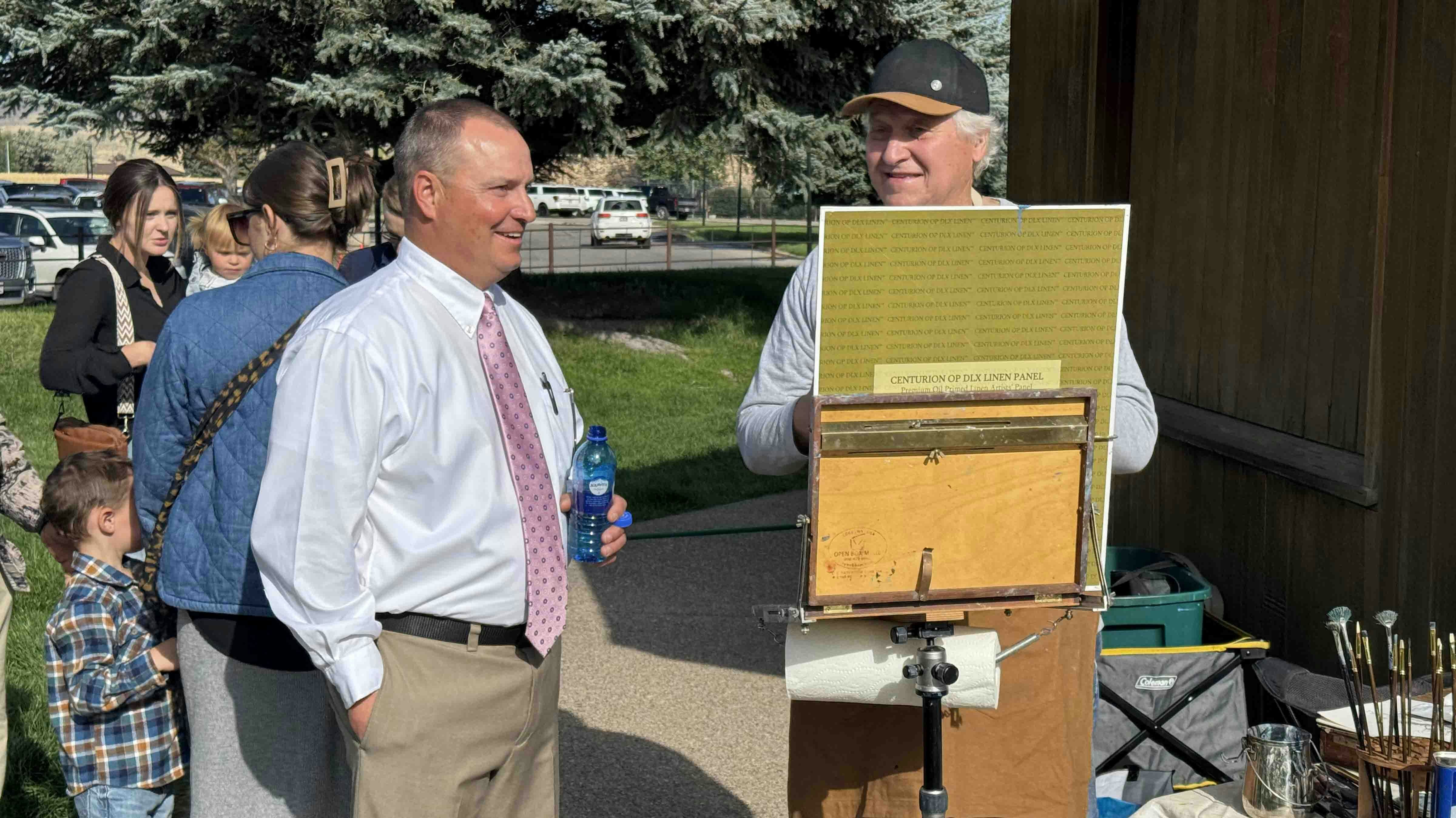 Auctioneer Troy Black admires Michael Ome Untidet's work-in-progress during the 44th Buffalo Bill Art Show and Sale's Saturday morning Quick Draw auction.