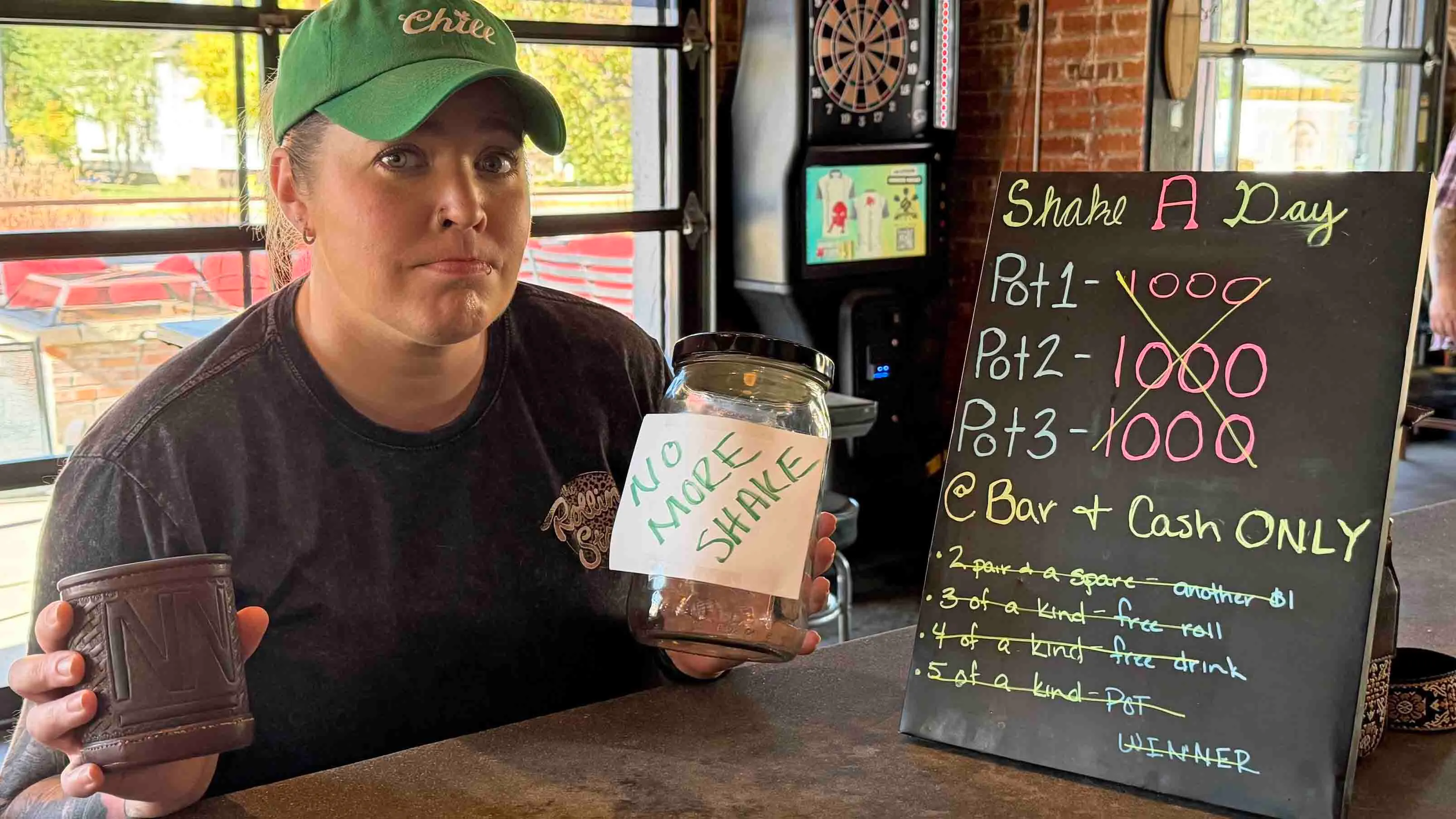 Sheridan's "No Name Bar" employee Tierney Clark holds up shake a day cups