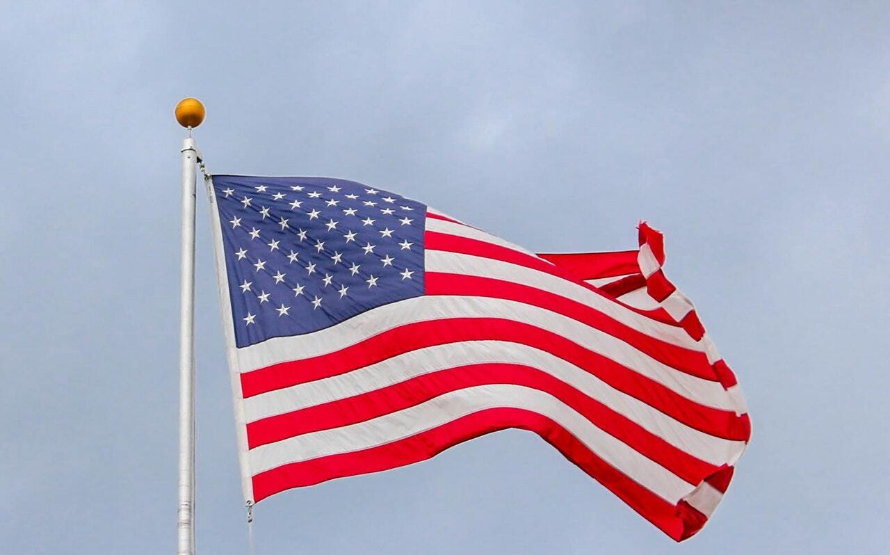 Usa flag waving on white metal pole 1550342