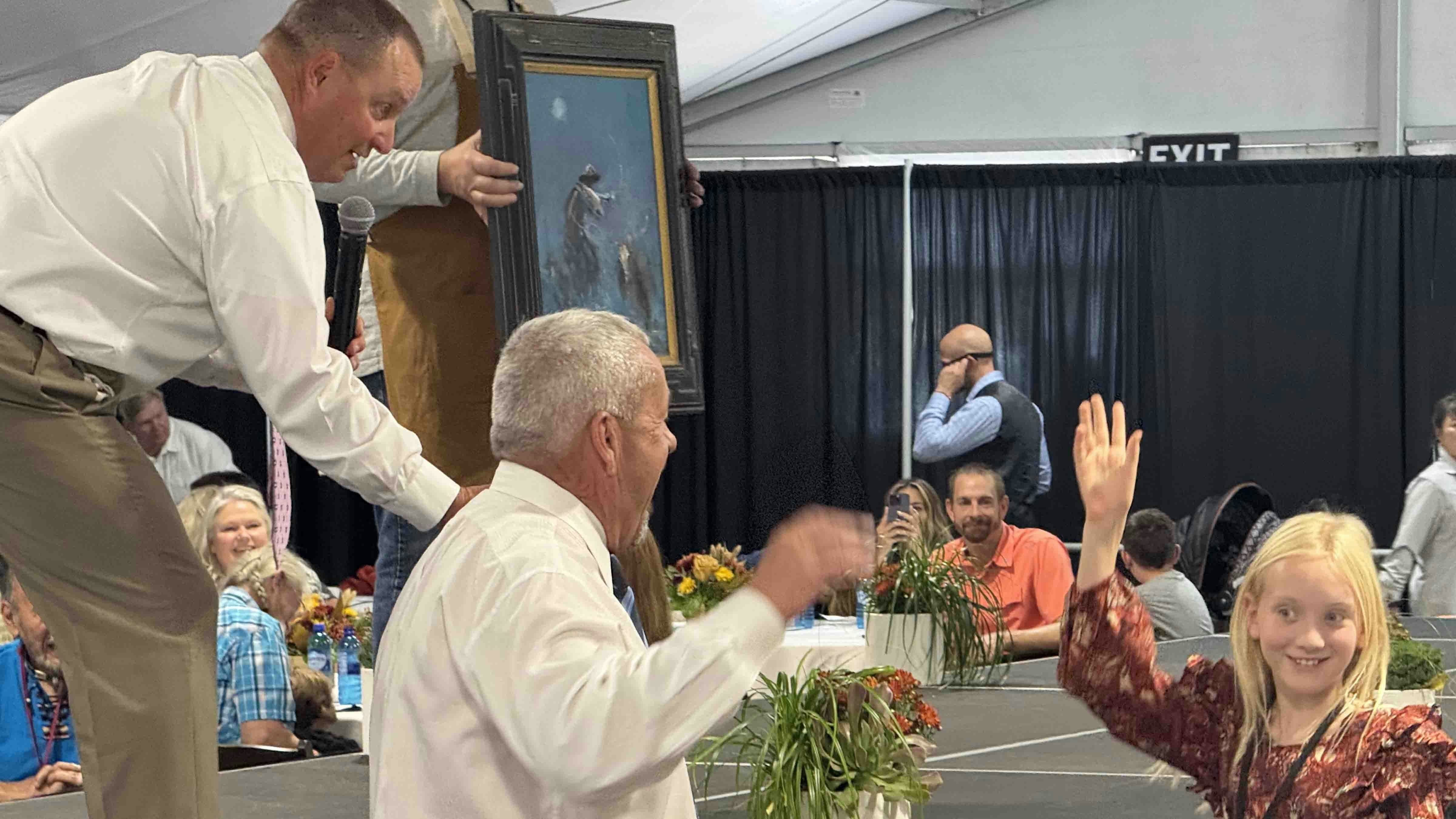 Vaughn Holley, 10, bids on a painting by Michael Ome Untiedt during the 44th Buffalo Bill Art Show and Sale's Saturday morning Quick Draw auction. She helped add some paint to the piece, and her family acquired it for $5,000.