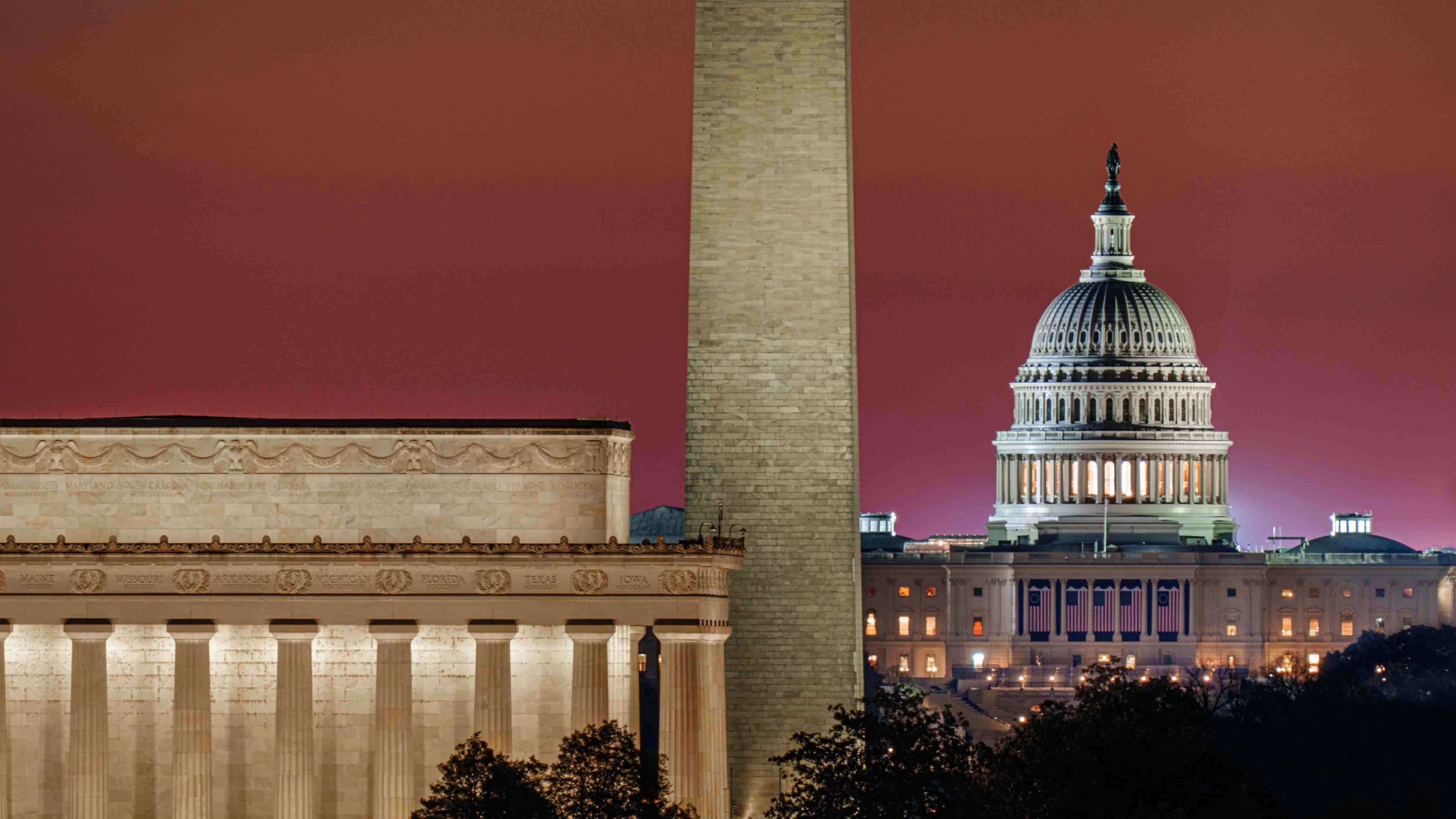 Daybreak turns the horizon red behind the (L-R) Lincoln Memorial, Washington Monument, and the U.S. Capitol in Washington, DC.