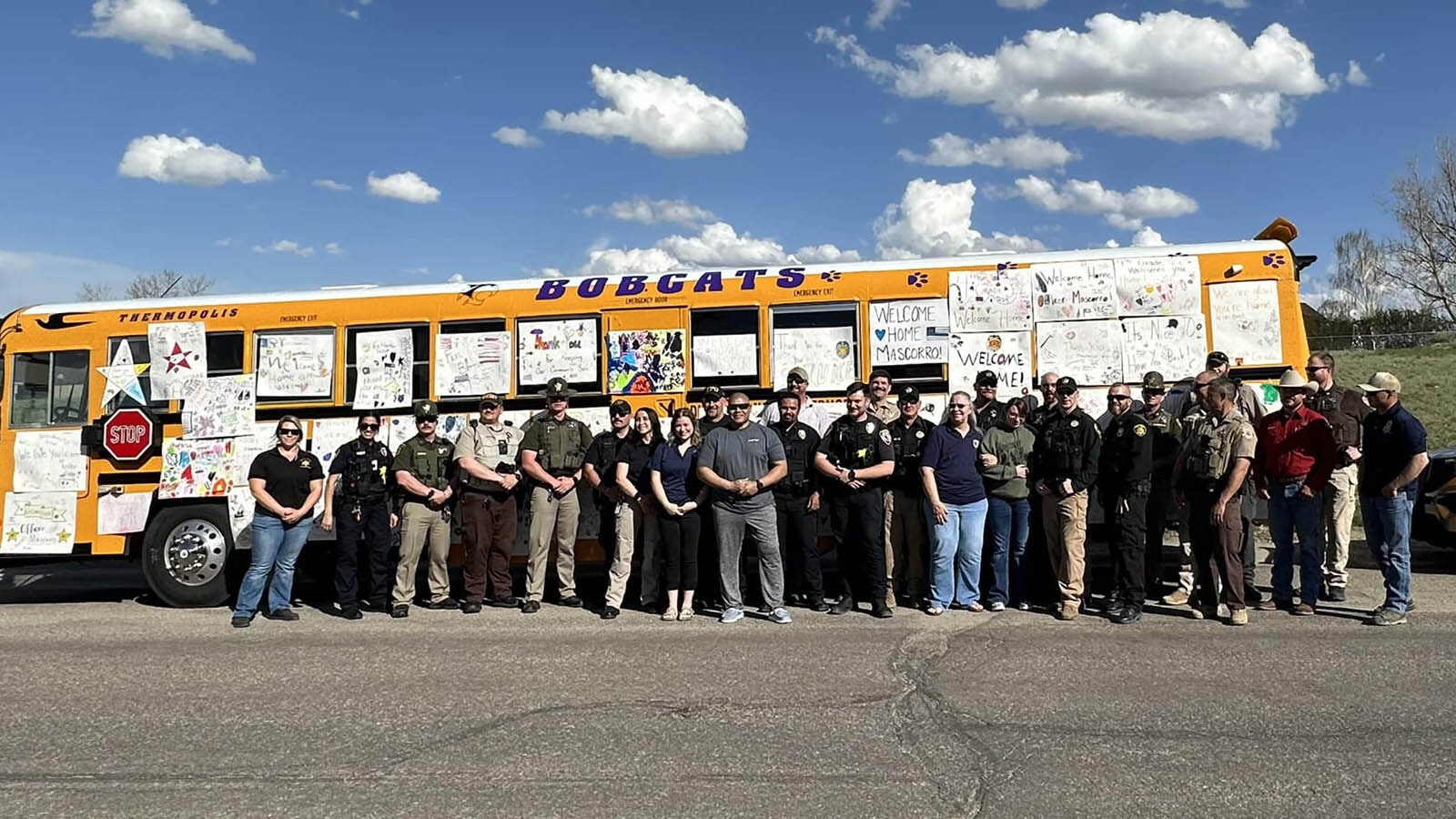 Messages from local schoolchildren are plastered on the side of a bus as area law enforcement welcomed Thermopolis Police Sgt. Mike Mascorro home from the hospital Wednesday. He was wounded in the line of duty in a shootout with a suspect April 28.