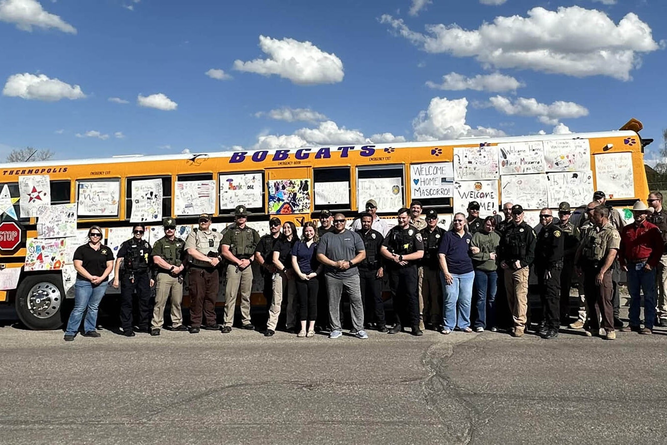 Messages from local schoolchildren are plastered on the side of a bus as area law enforcement welcomed Thermopolis Police Sgt. Mike Mascorro home from the hospital Wednesday. He was wounded in the line of duty in a shootout with a suspect April 28.