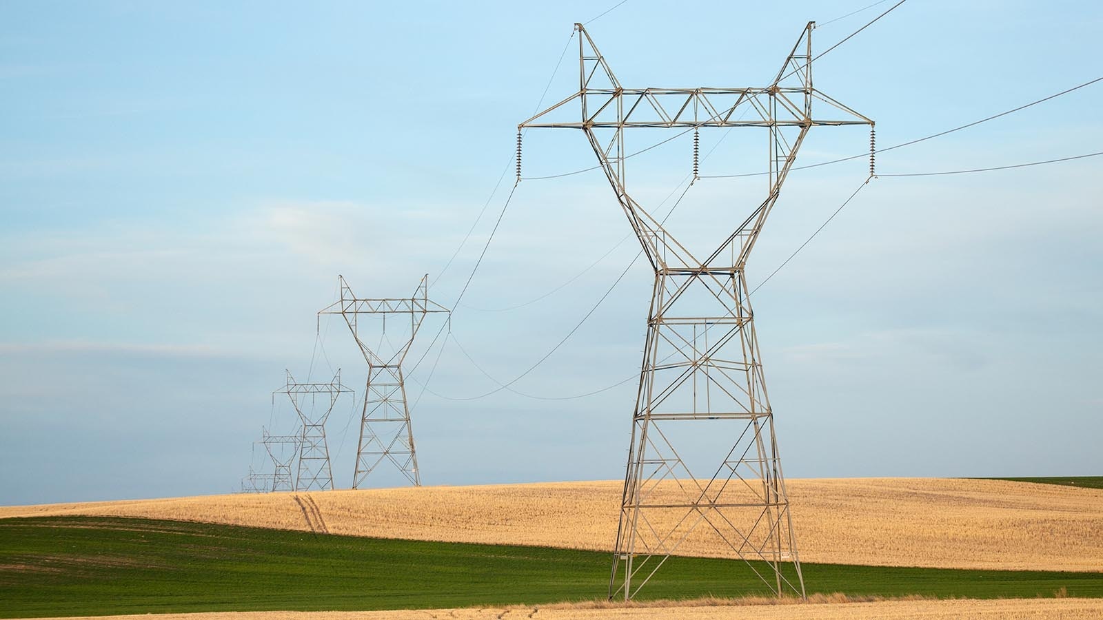 A row of high-voltage power transmission lines running through southern Wyoming.