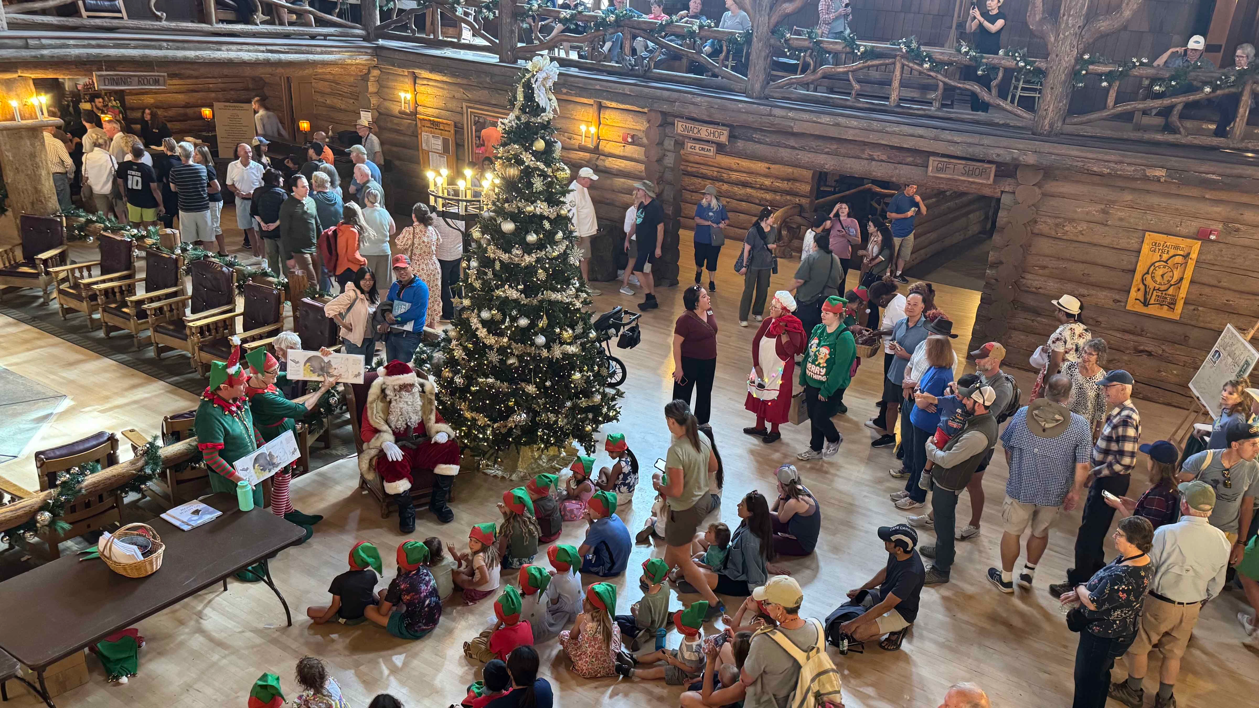 Santa Claus and his elves entertain tourists in the towering lobby of the Old Faithful Inn in an August tradition.