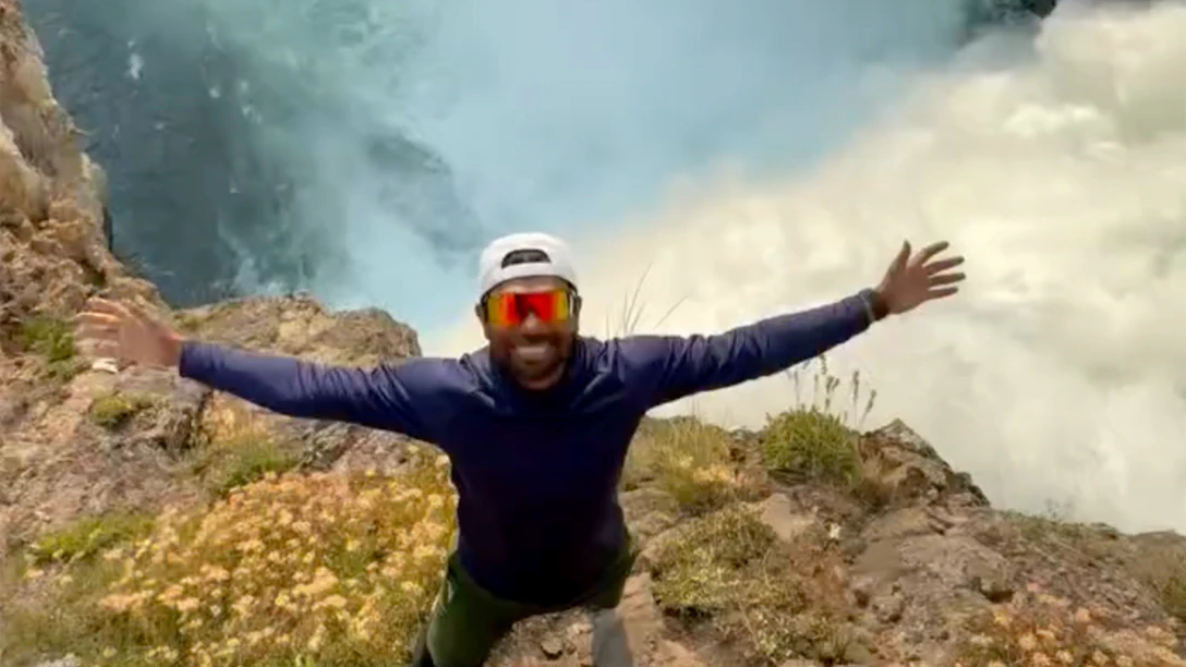 A dimwitted tourist shared a video of himself illegally perched above the 109-foot-tall summit of the Upper Falls of the Grand Canyon in Yellowstone.