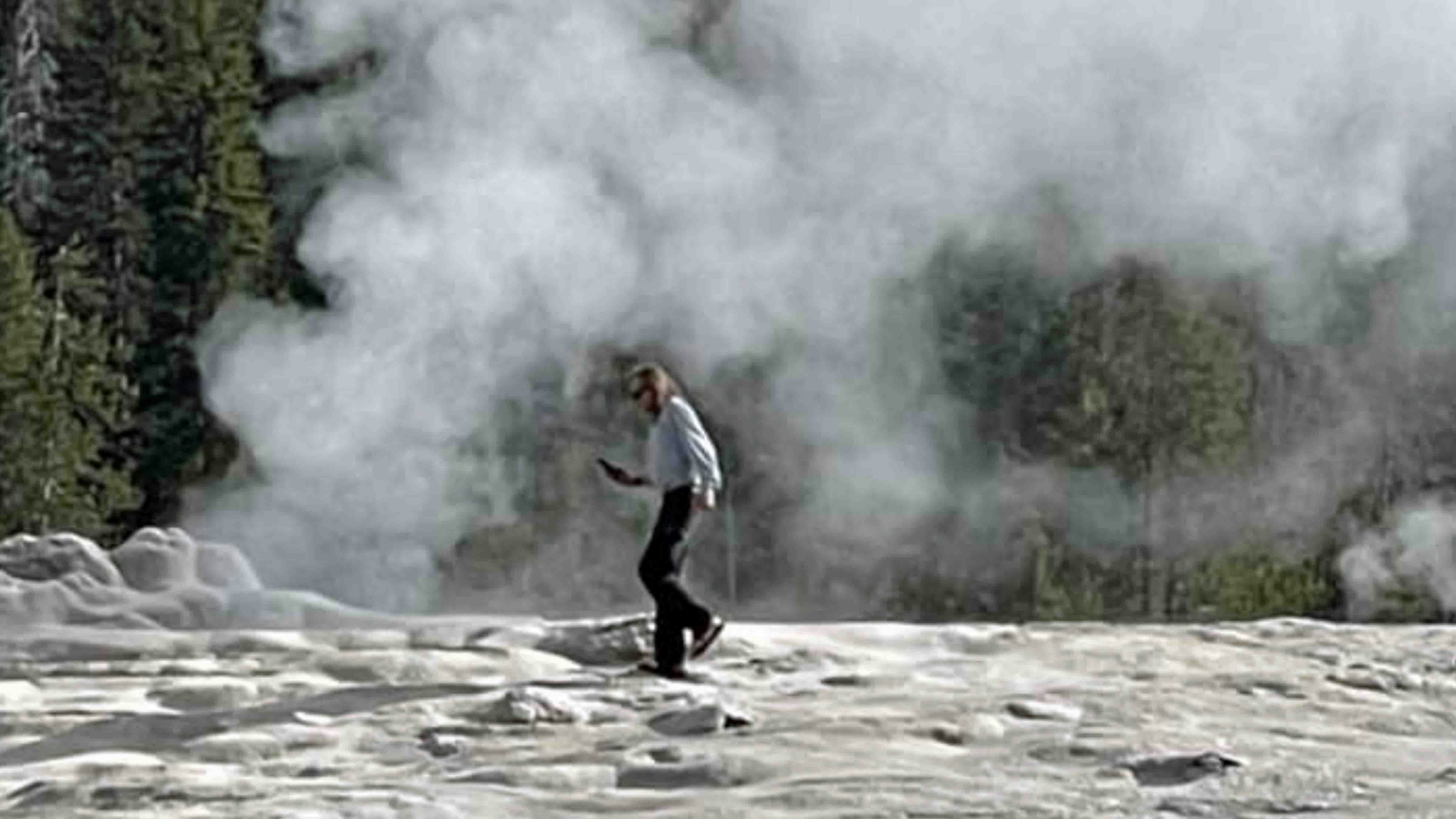 Unidentified man walks on thermal feature at Yellowstone National Park (FILE)